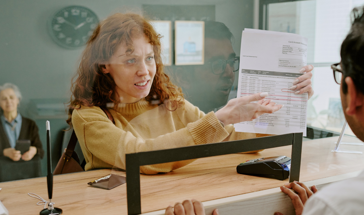 Scene showing woman discussing documents with bank employee