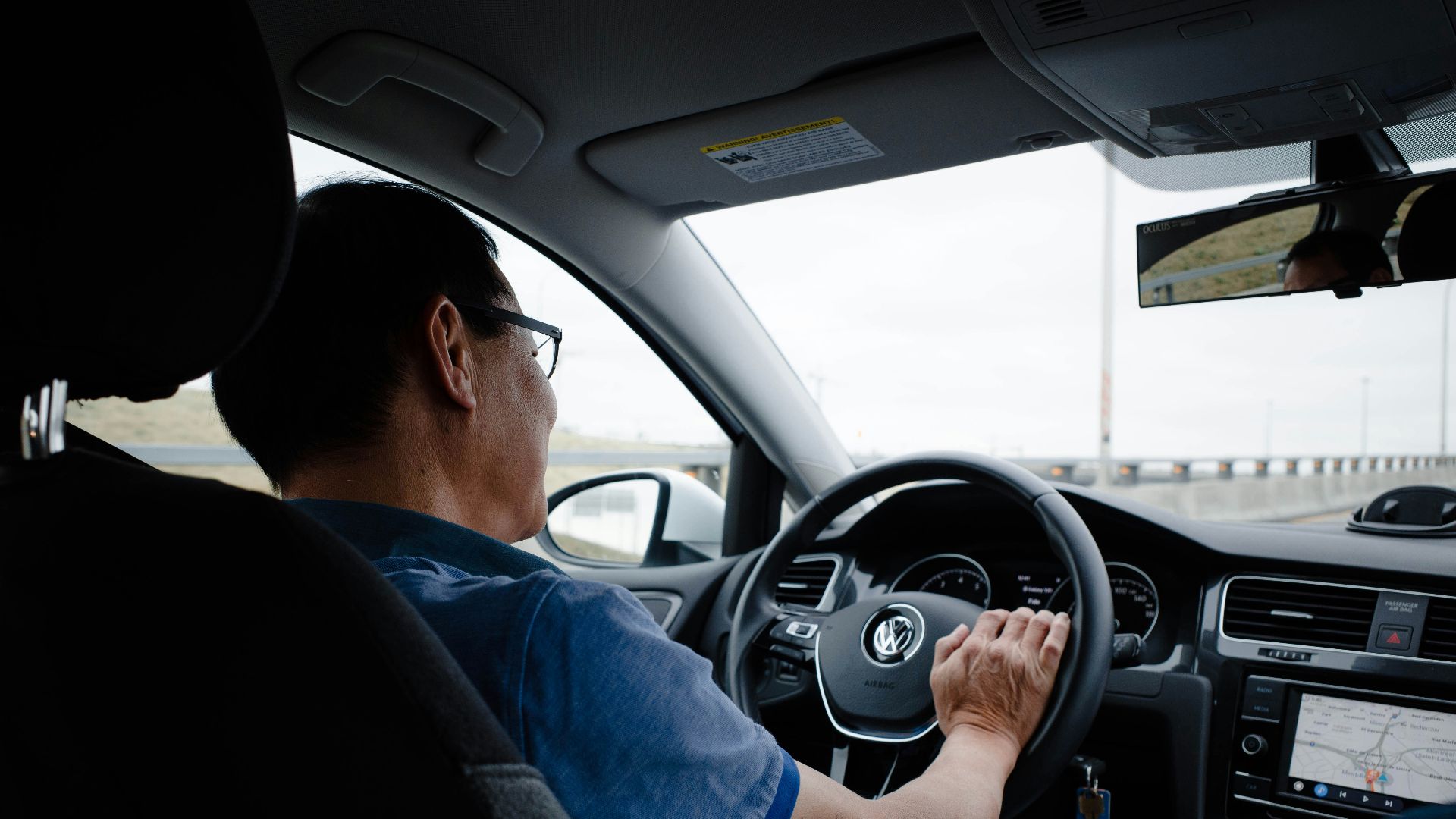 a man driving a car on a highway