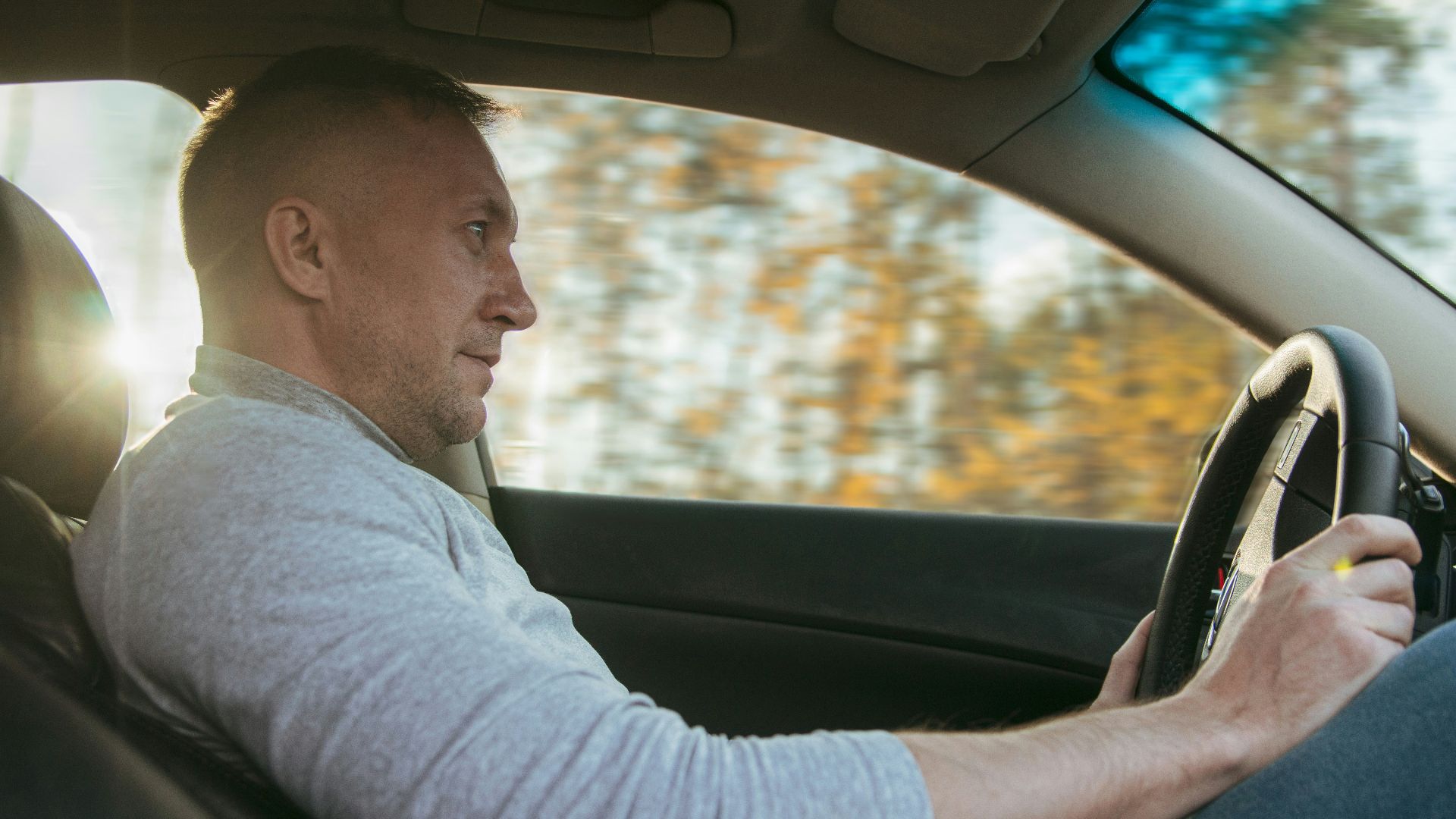 Man driving a car on a sunny day