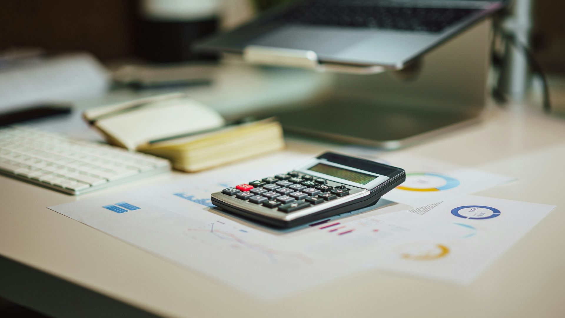 a calculator sitting on top of a table next to a laptop
