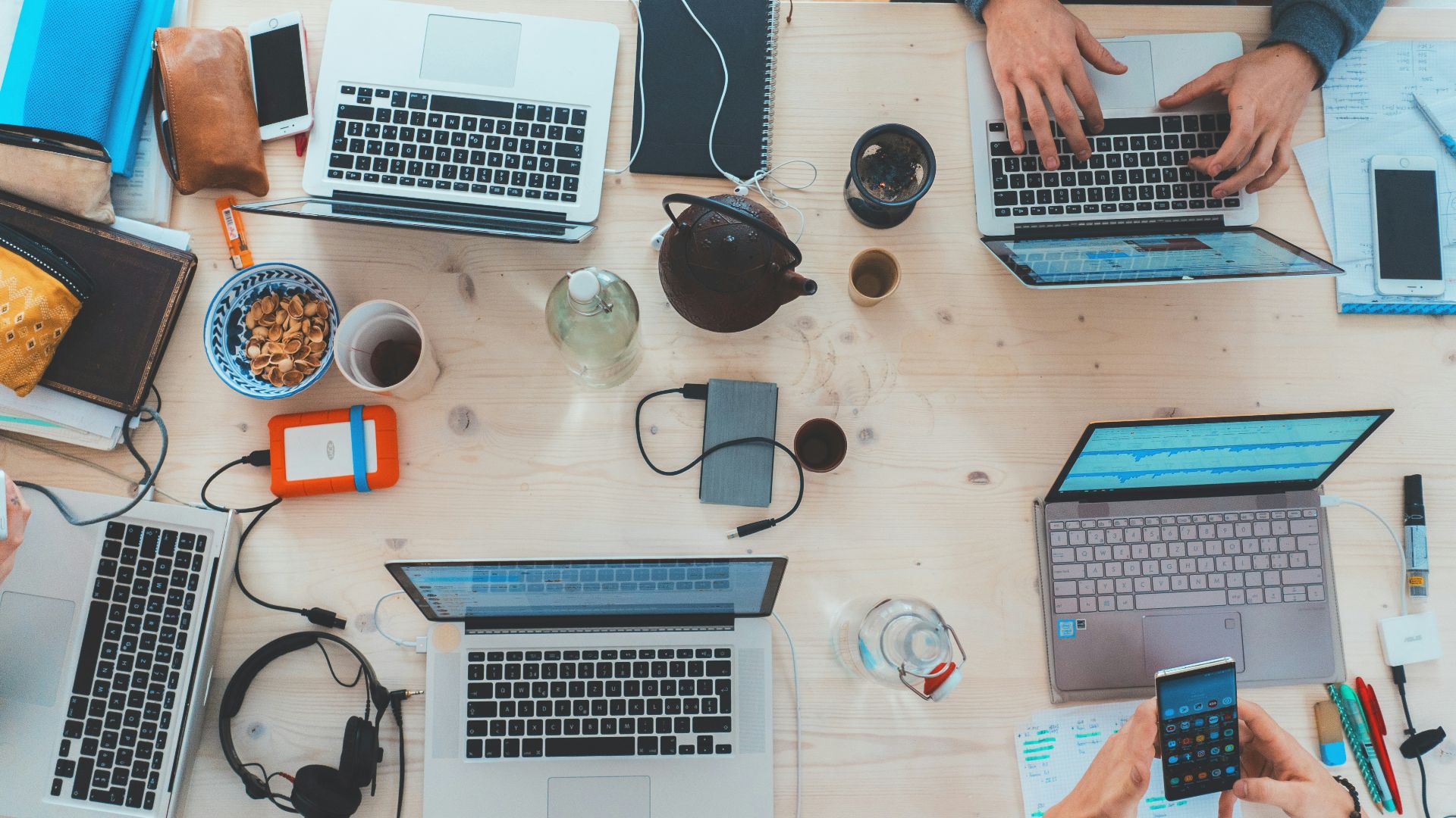 people sitting down near table with assorted laptop computers
