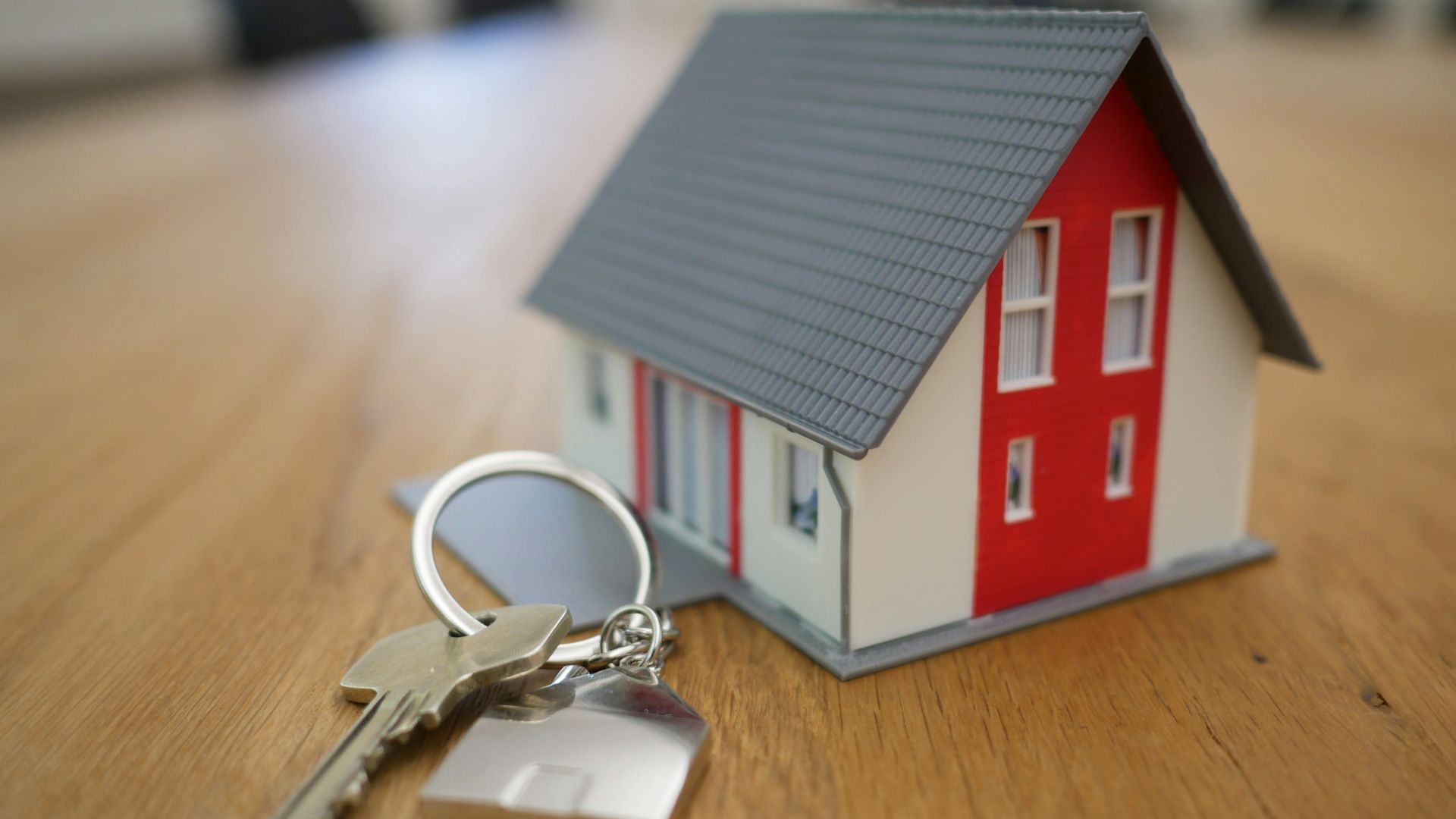 white and red wooden house miniature on brown table