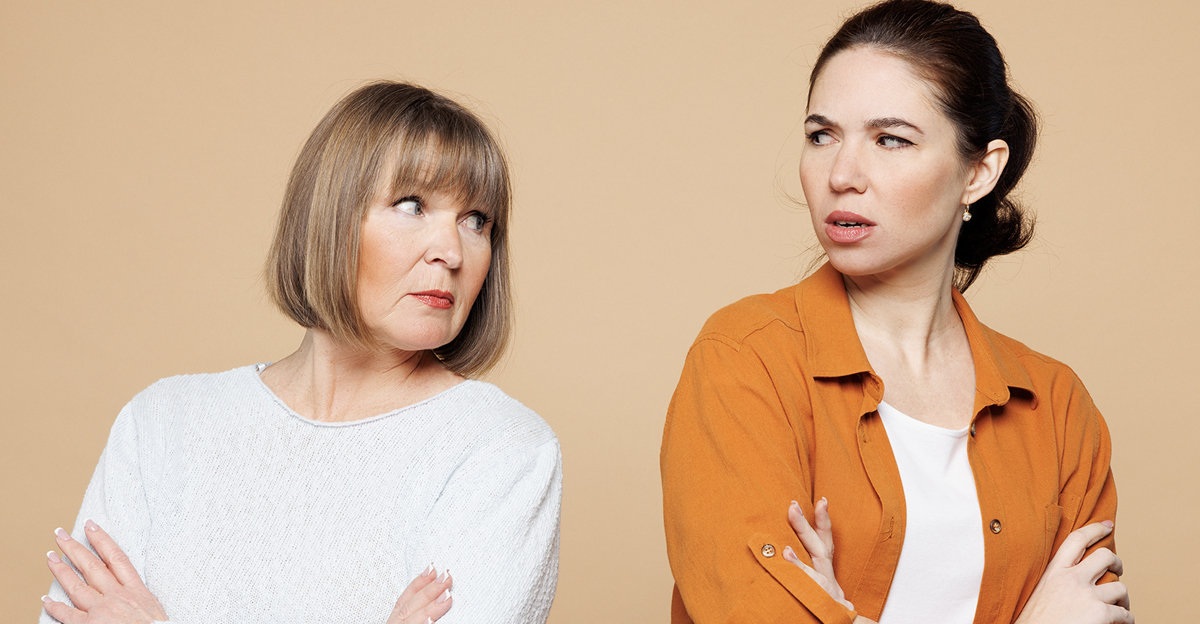 Elder sad mad offended parent mom 50s years old with young adult daughter two women together wear casual clothes hold hands crossed folded isolated on plain light beige background. Family day concept