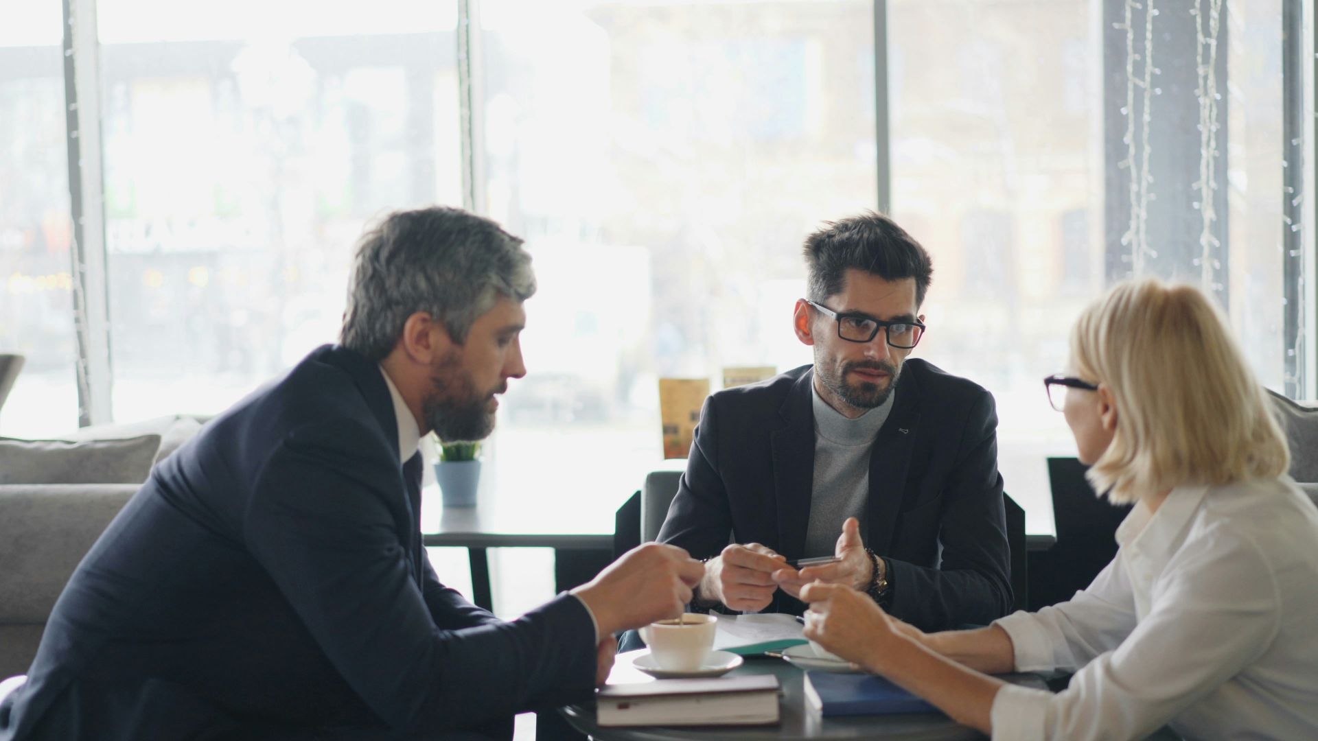 a group of people sitting around a table talking