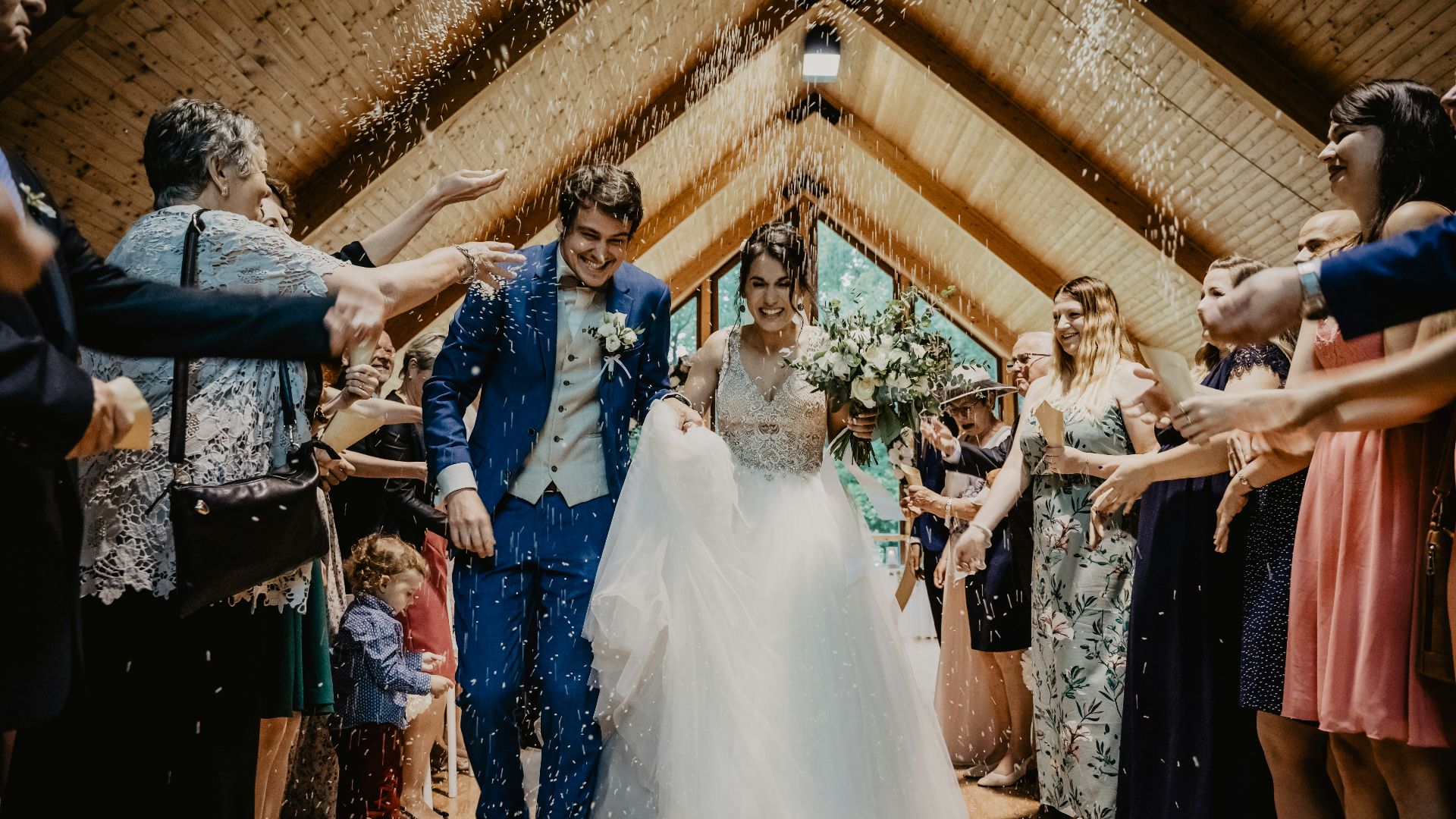 bride and groom standing beside brown wooden wall