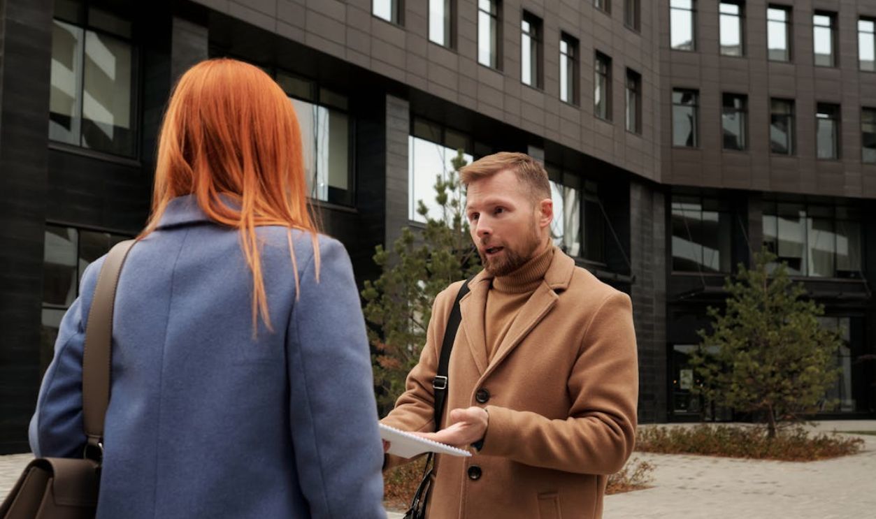 Two business professionals in conversation outside an urban office building