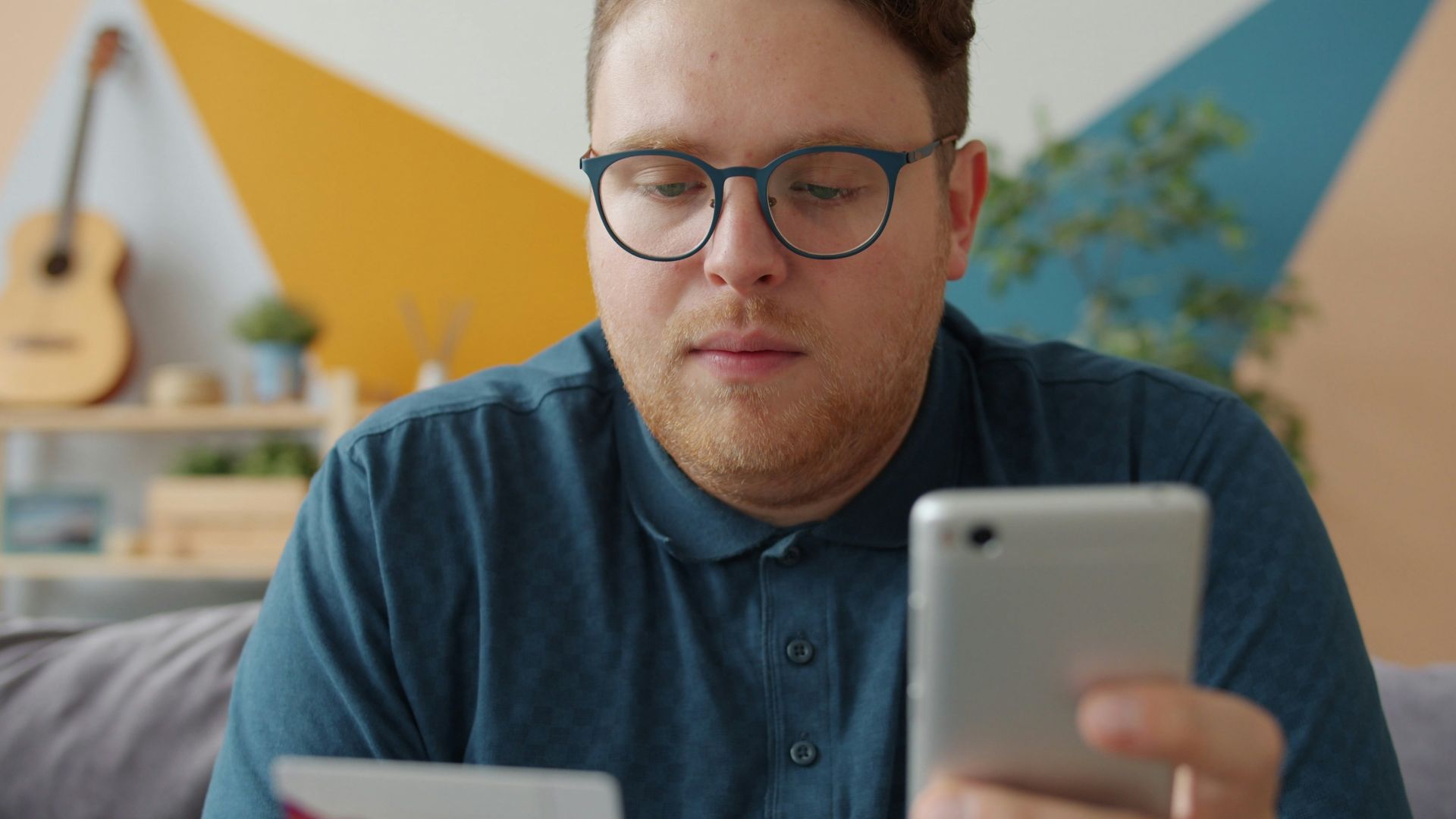 Man holding credit card and smartphone for online shopping.