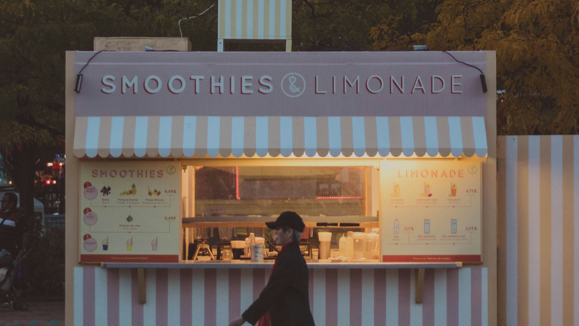 a person walking past a small food stand