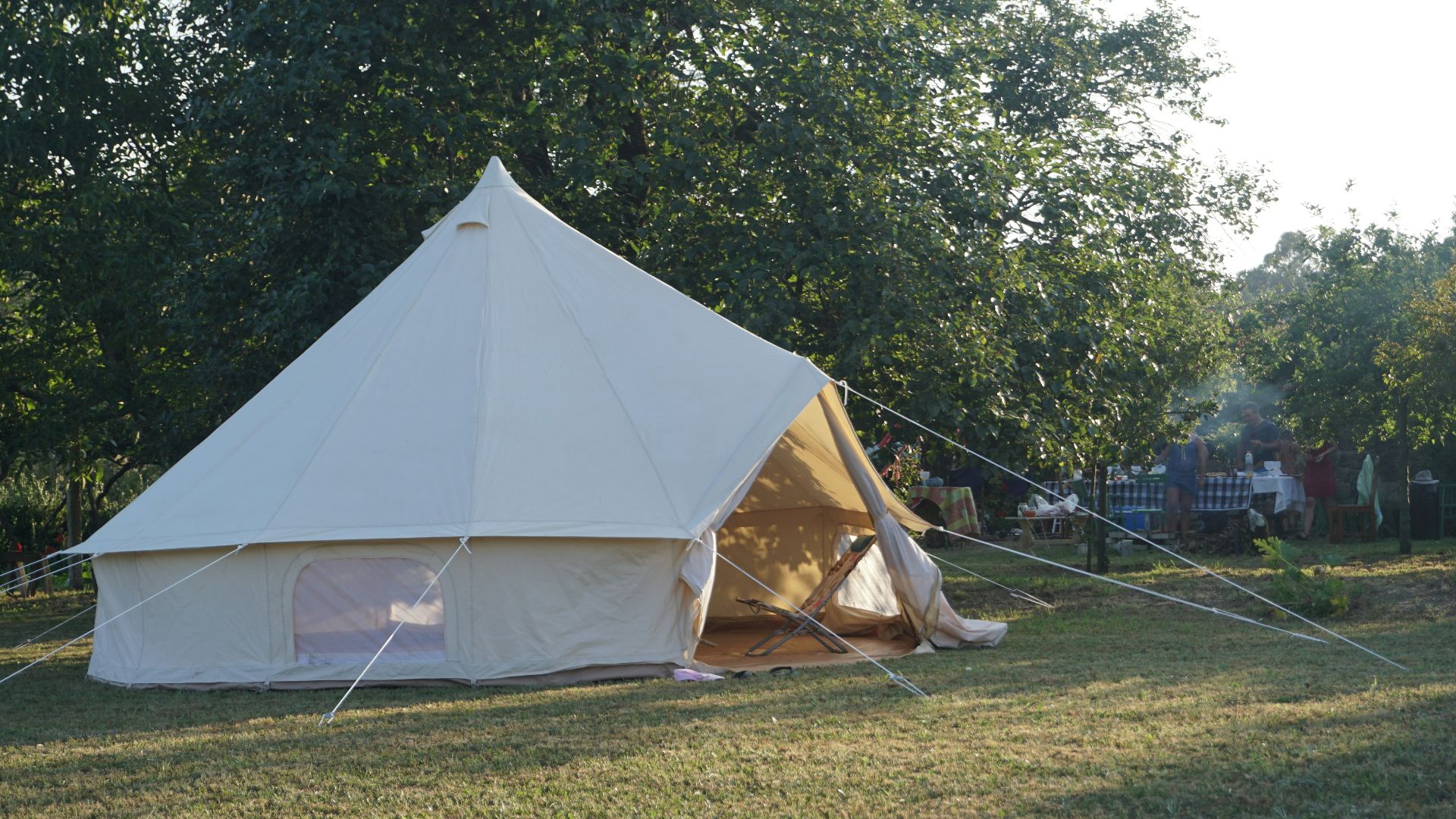 A large white tent sitting on top of a lush green field