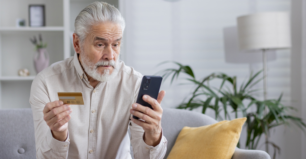 A senior man in a white shirt with gray hair and a beard is sitting on the sofa at home