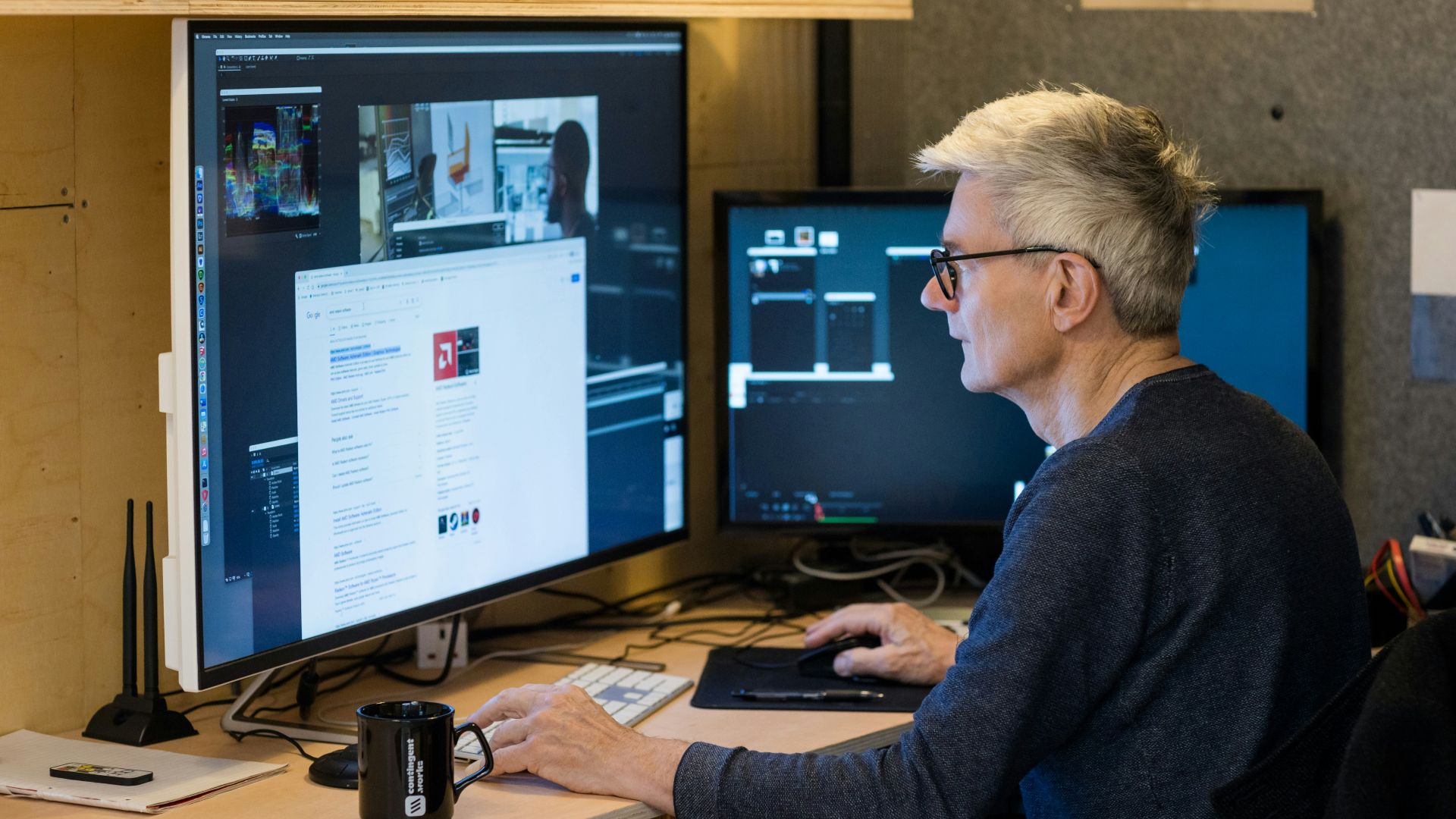 a man sitting in front of a computer monitor