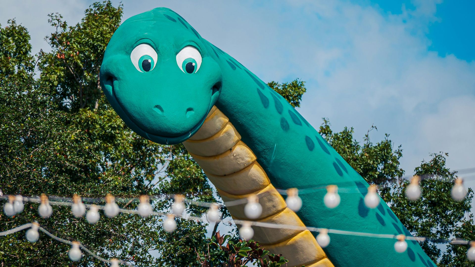 a large inflatable dinosaur with eyes on a string