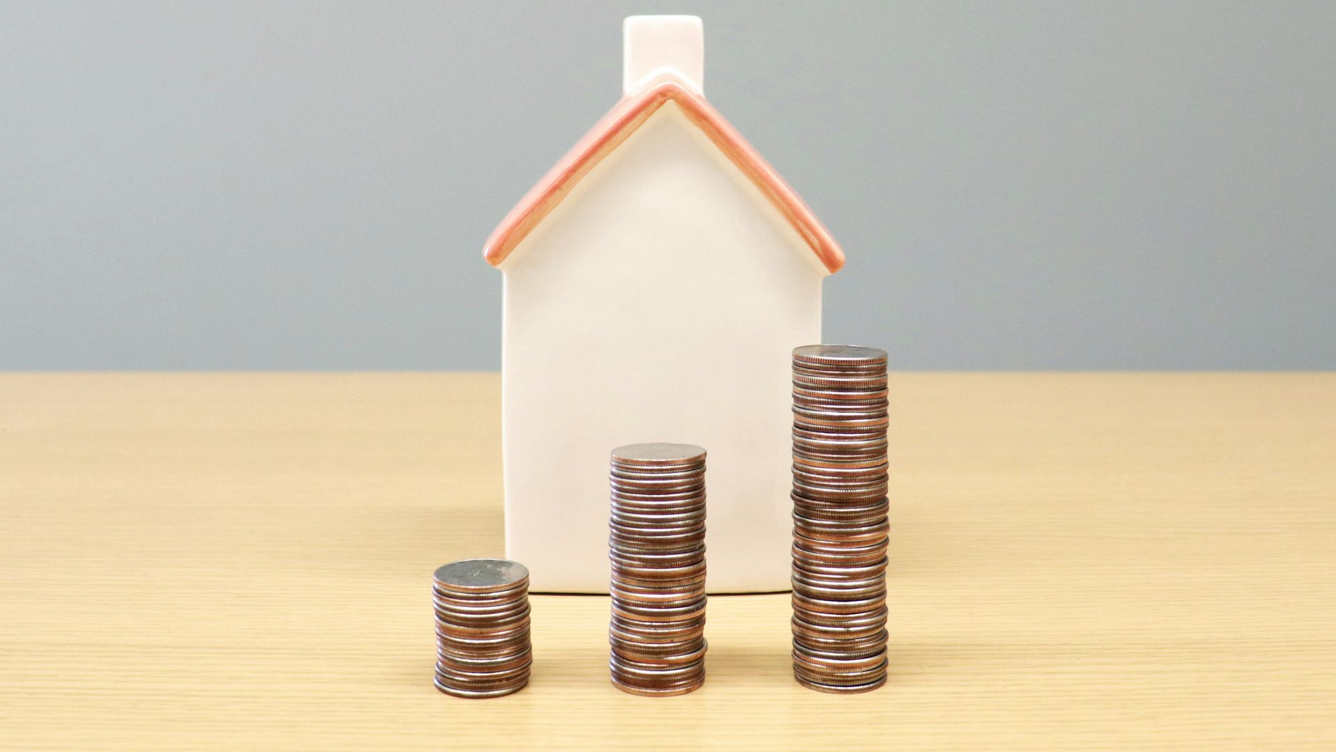 a house and stacks of coins on a table