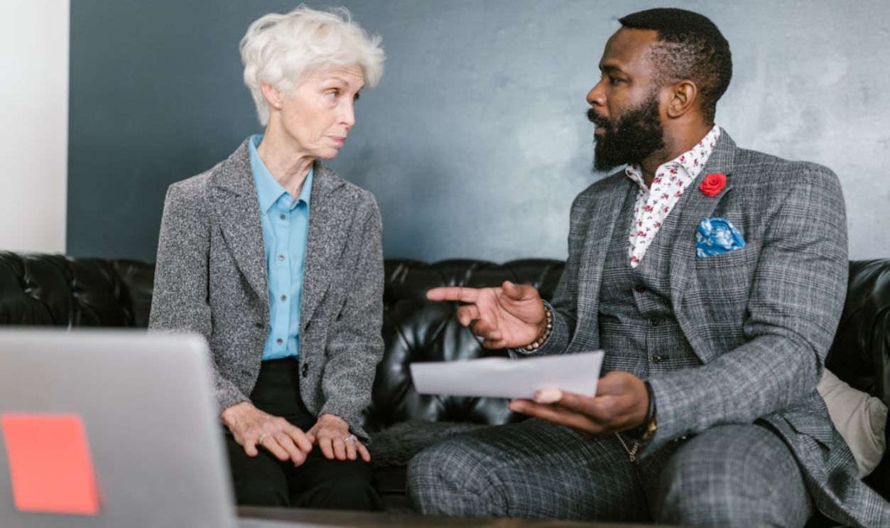 A focused business meeting between two colleagues discussing documents inside a modern office
