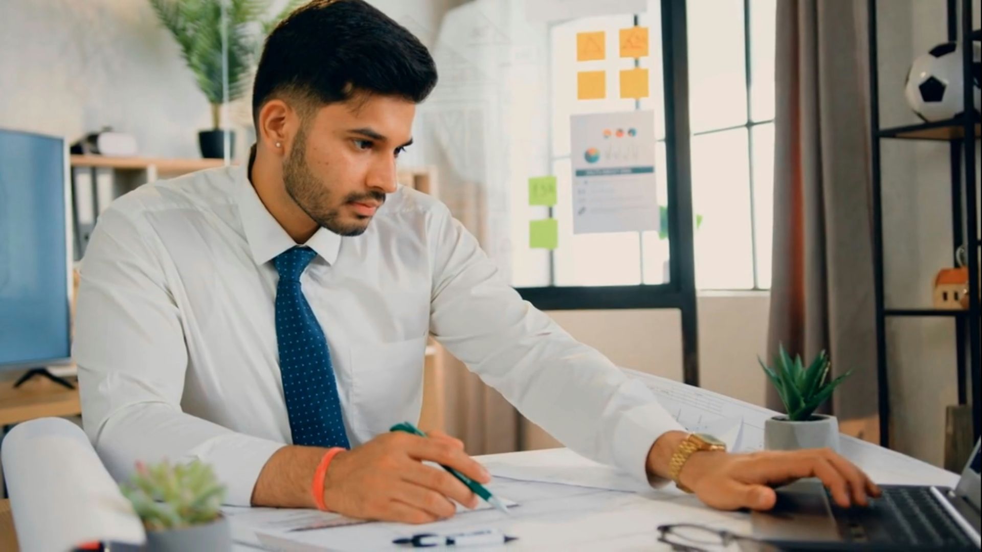 a man sitting at a desk working on a laptop