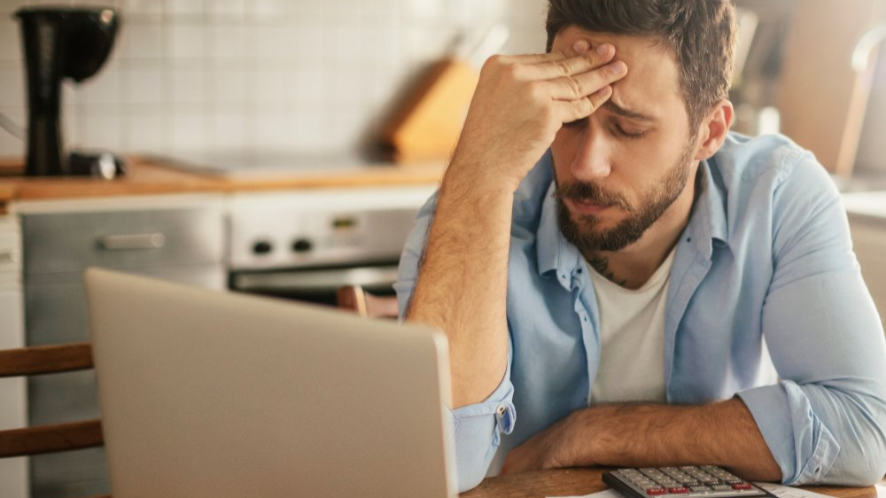 Worried young man going over his bills and home finances