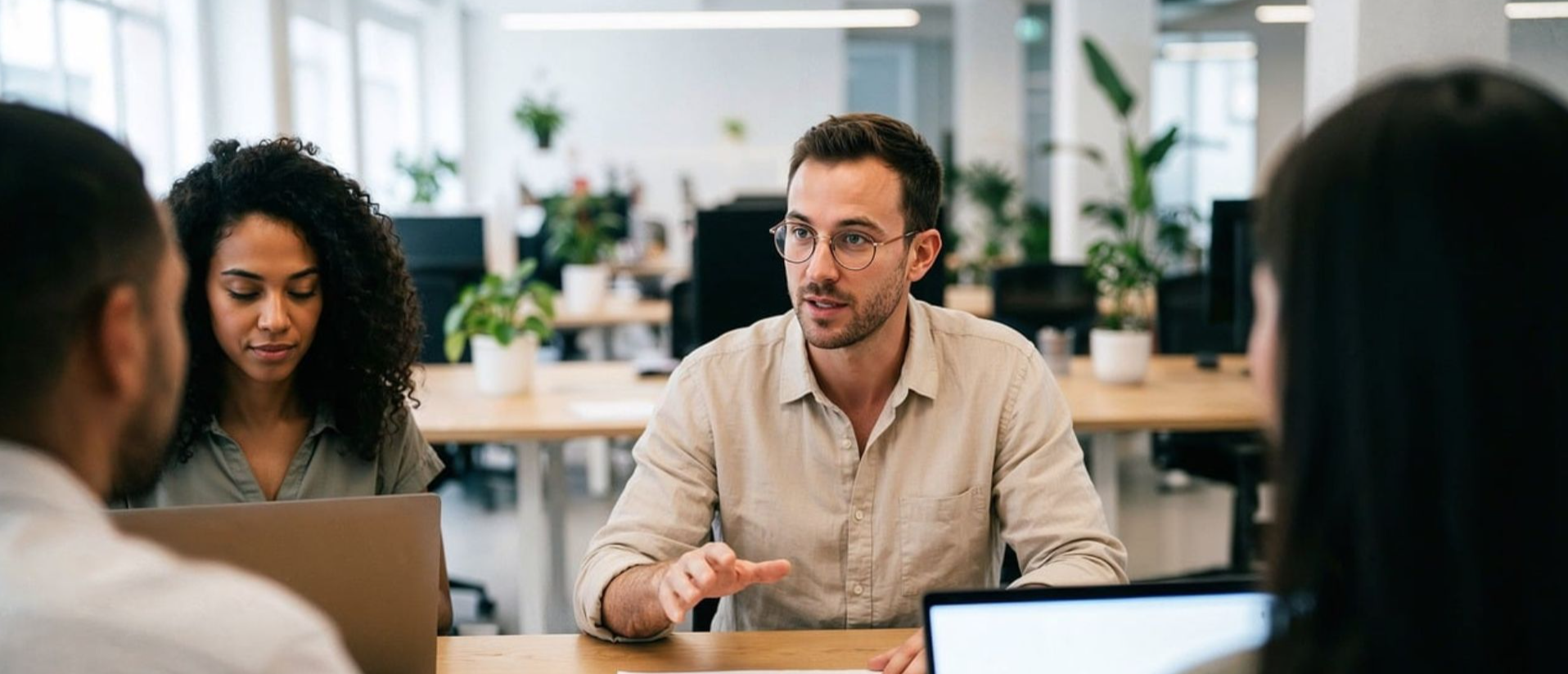 A couple managing finances with gadgets, documents, and coffee mugs at home.