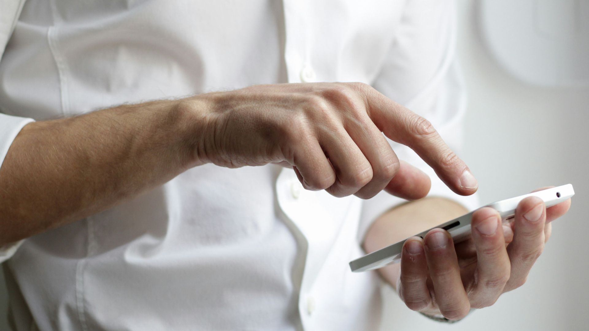 person holding white Android smartphone in white shirt