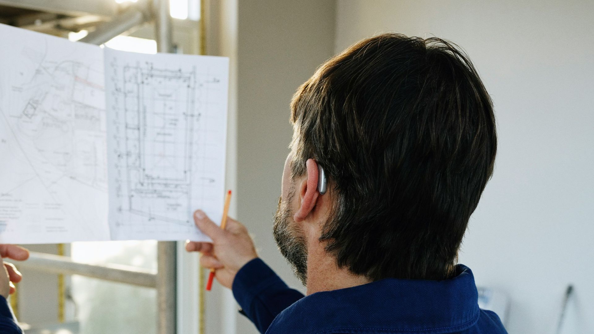 Man reviews blueprints at construction site