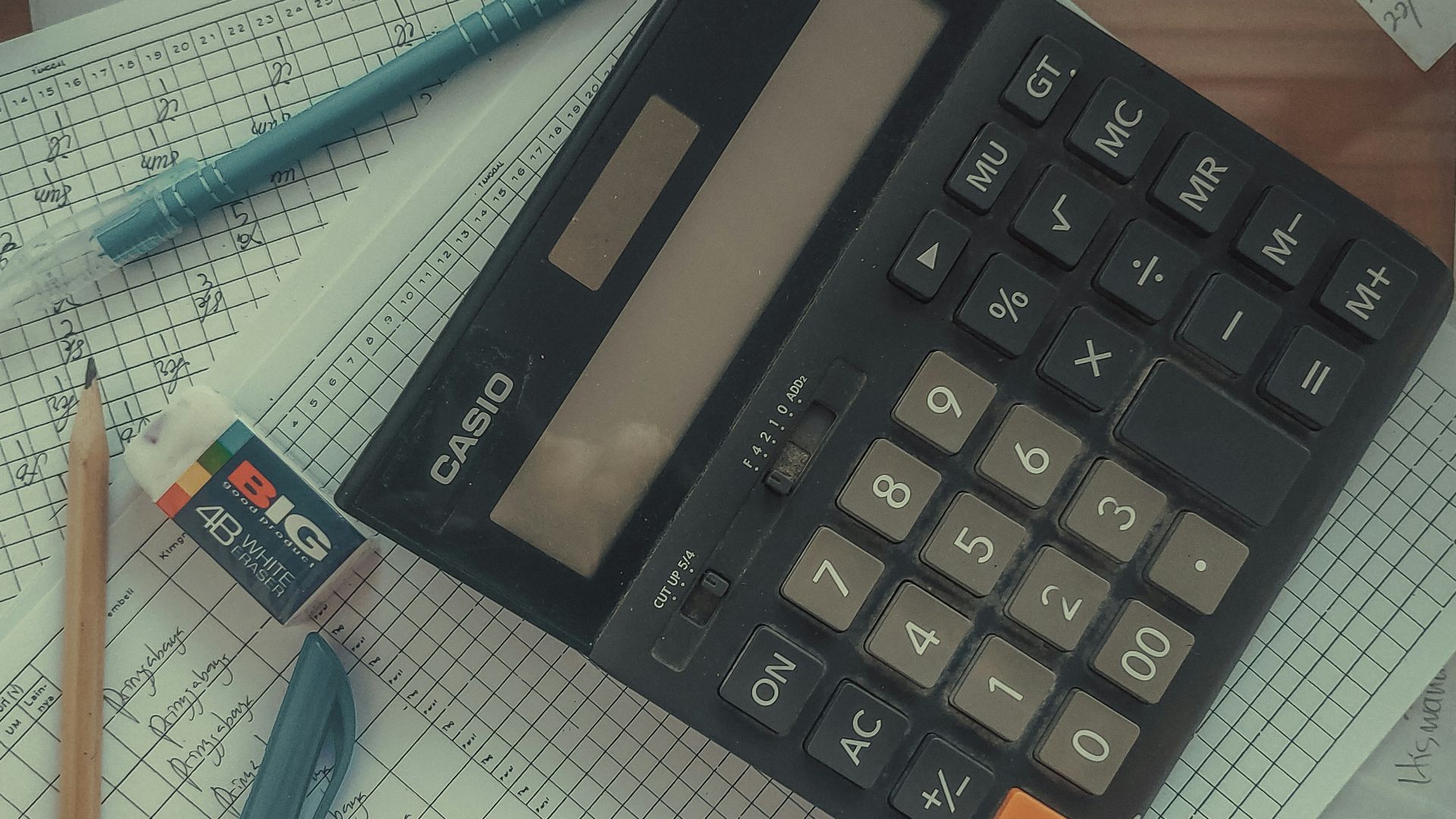 a calculator sitting on top of a pile of papers