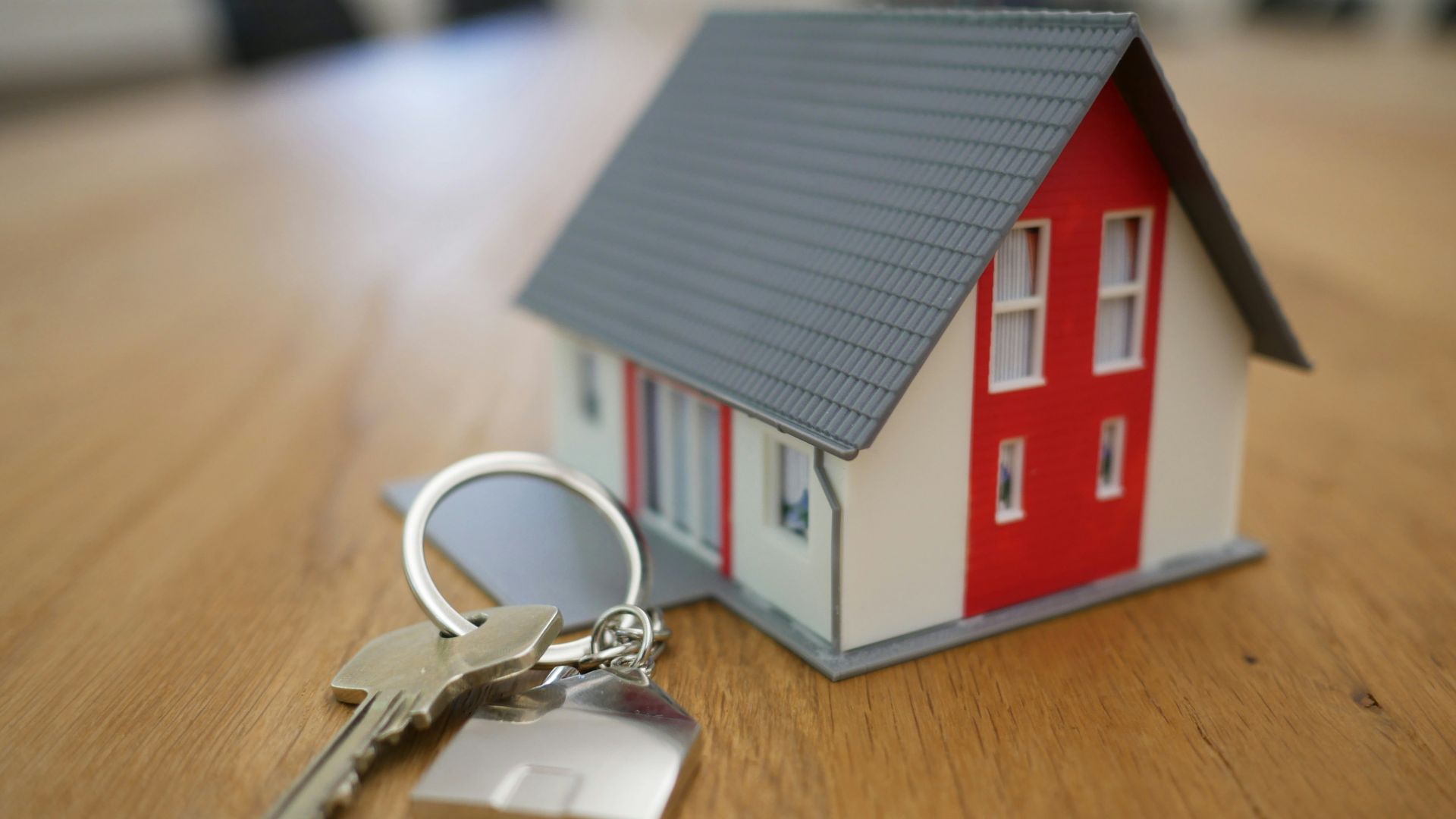 white and red wooden house miniature on brown table