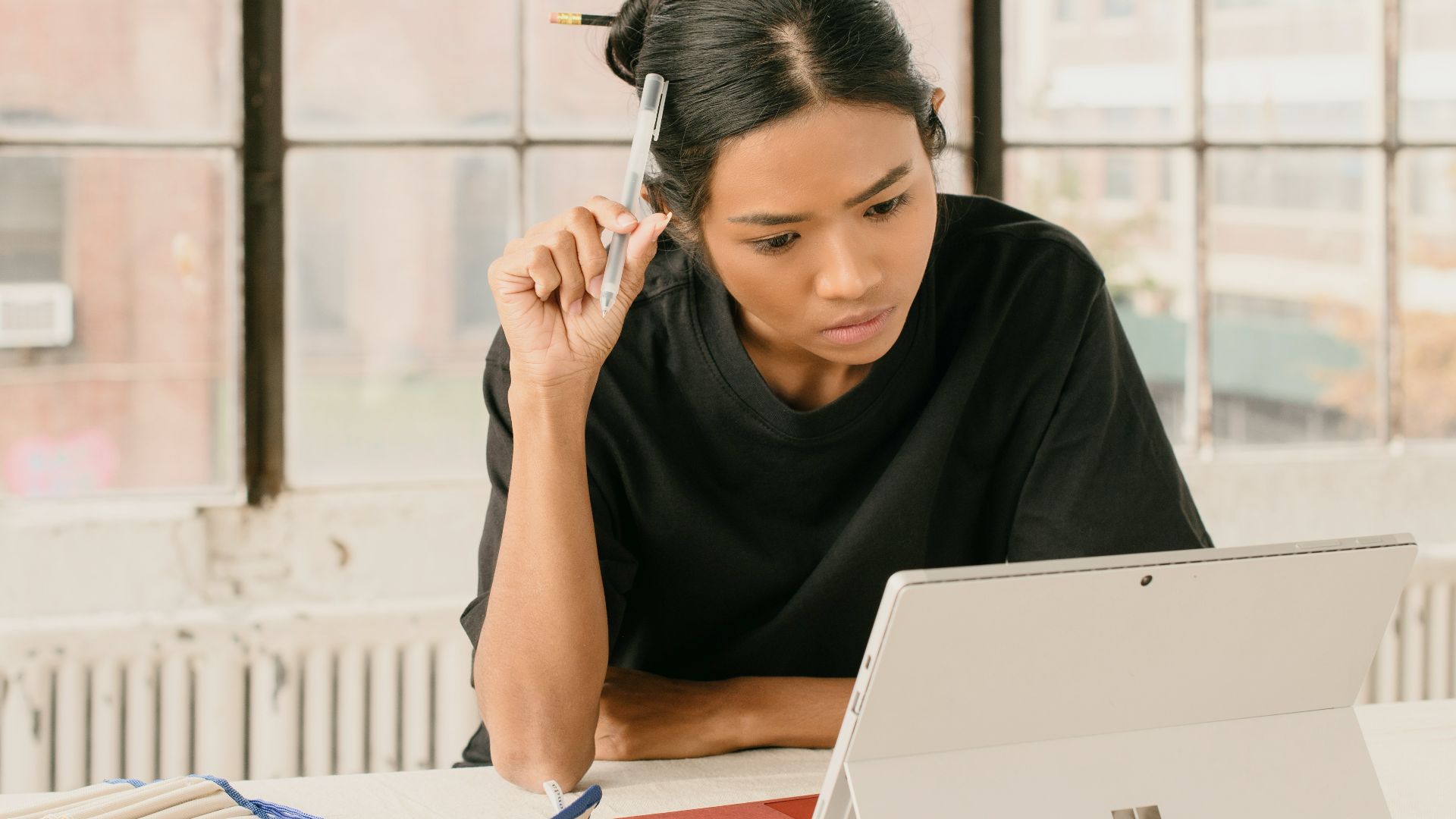 a woman sitting at a table using a laptop computer