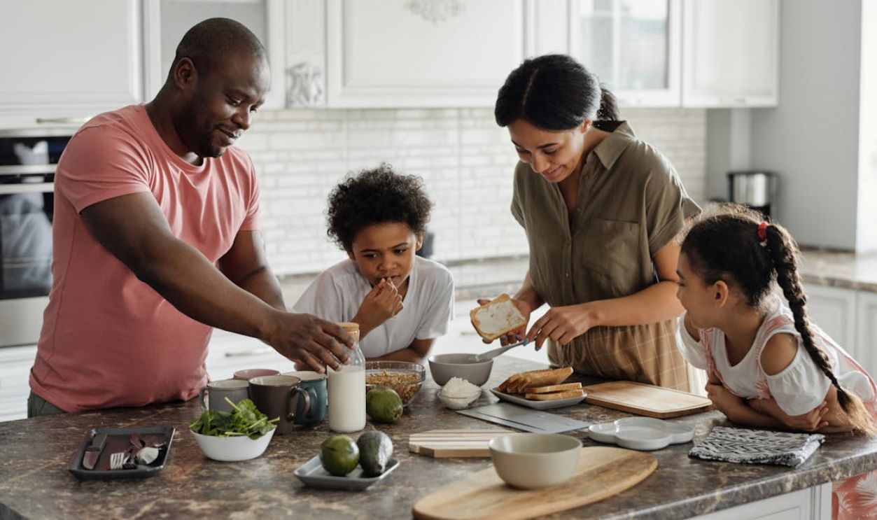A joyful family enjoys preparing a healthy meal together in their modern kitchen.