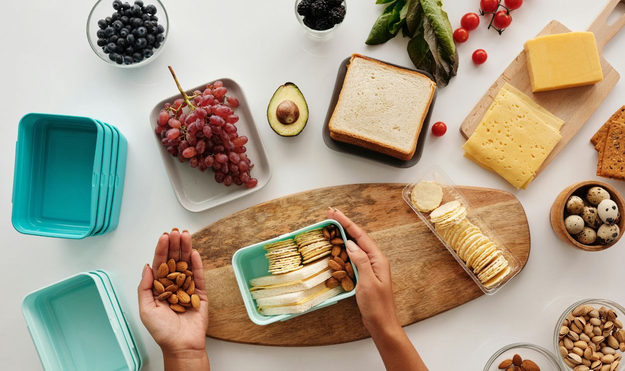 A vibrant flat lay of preparing a healthy snack with fresh ingredients like fruits, nuts, and cheese.