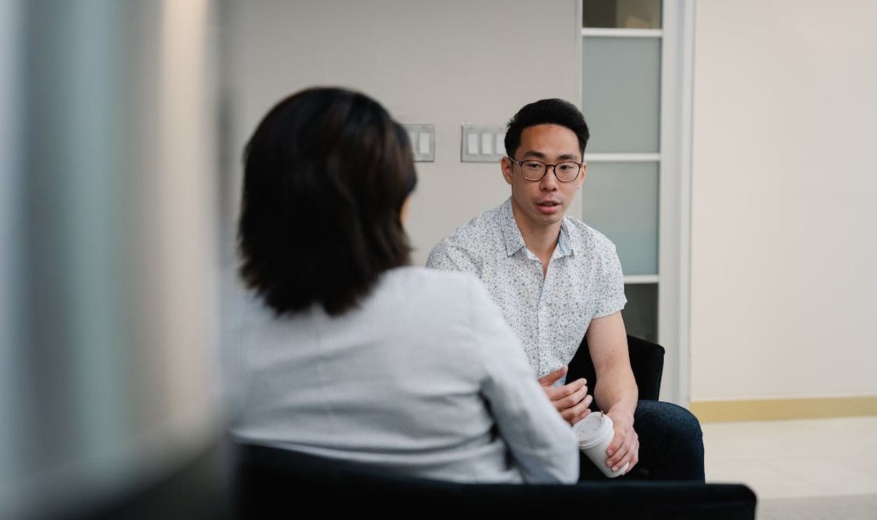 Two colleagues having a focused conversation in an office setting.
