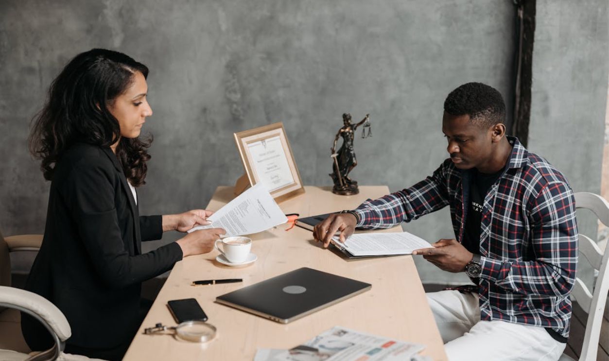 Business professionals discussing documents in a modern office setting.