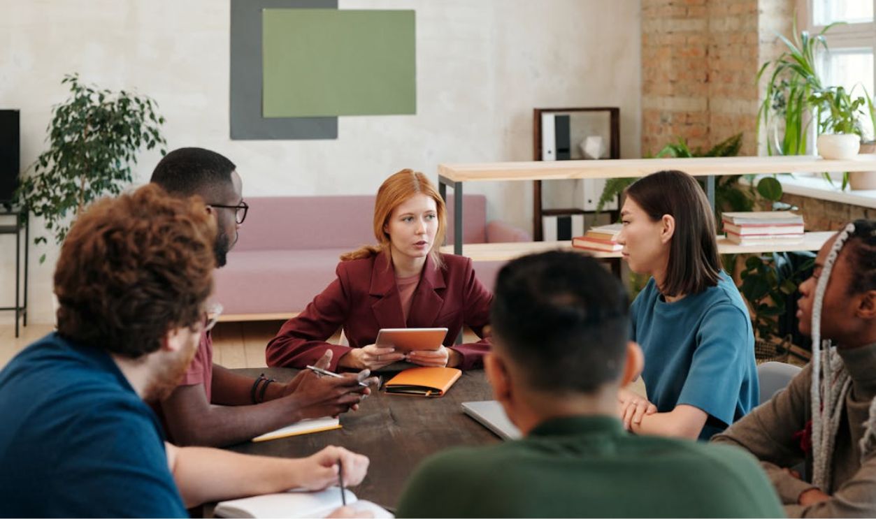 A diverse group of colleagues engaged in a meeting discussing ideas in a contemporary office setting.