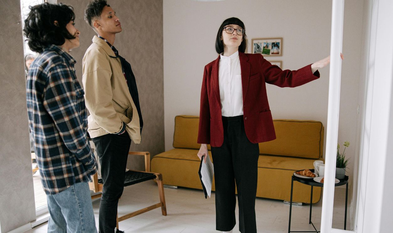 Realtor guiding potential buyers through a stylish apartment viewing.