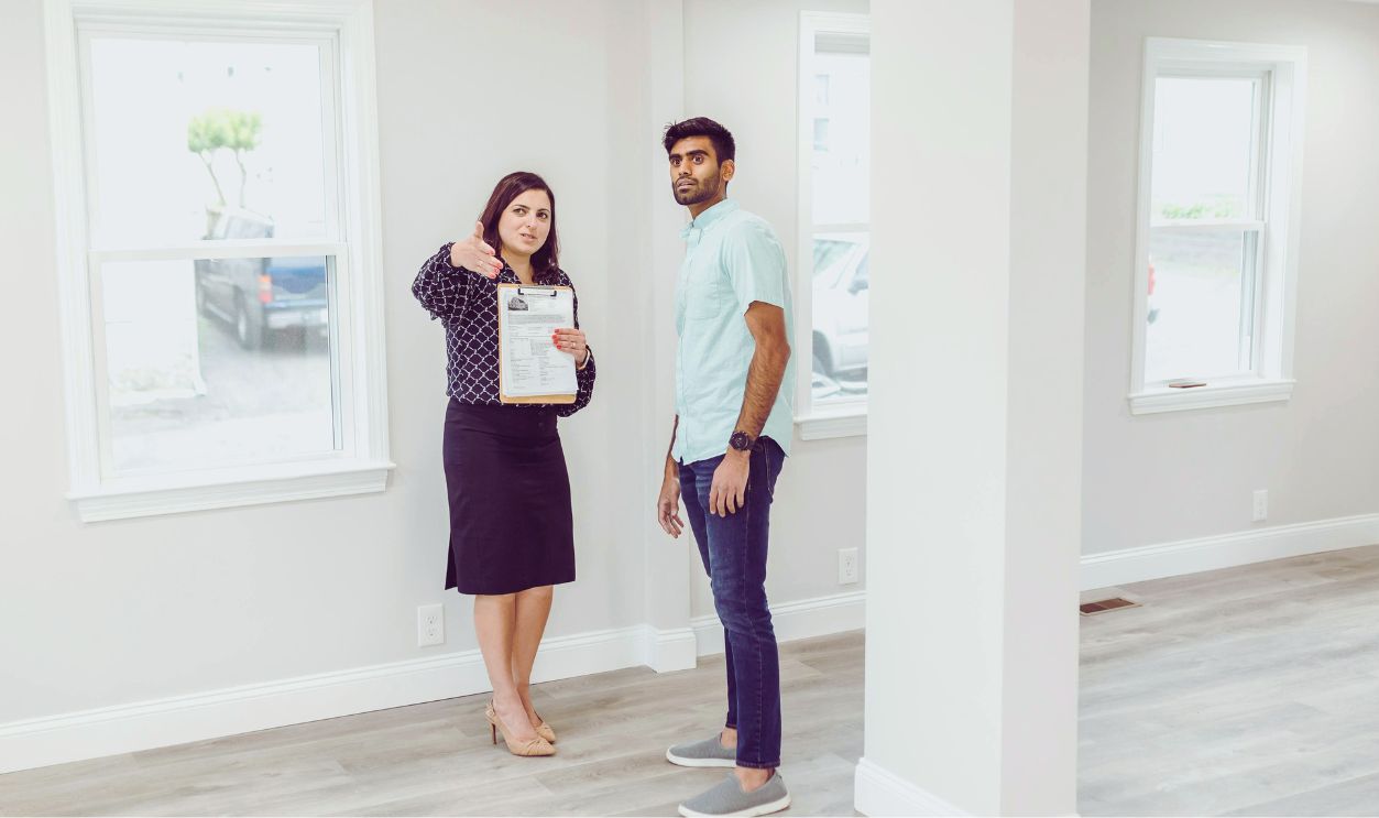 A real estate agent showing a potential buyer the interior of a new home.