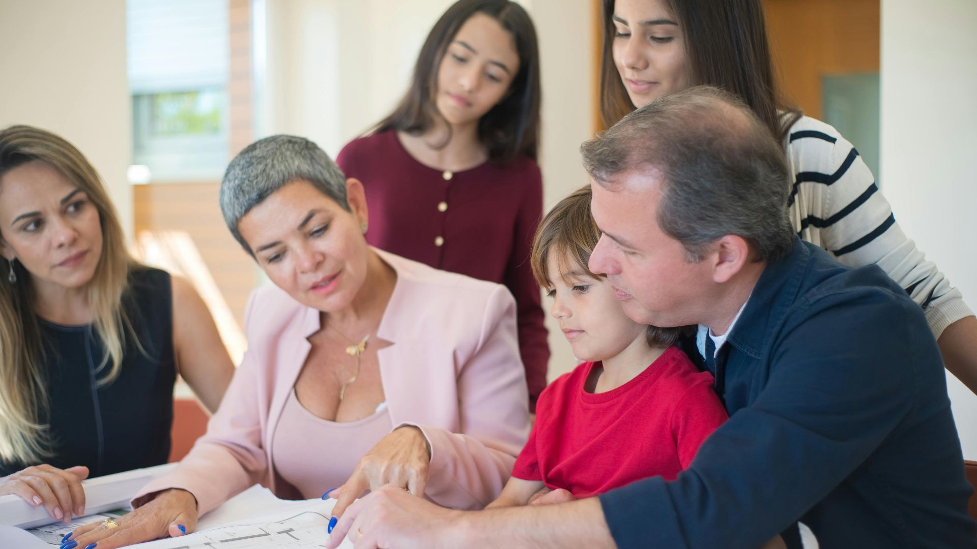 Family meeting with realtor to discuss house plans, emphasizing real estate decision-making.
