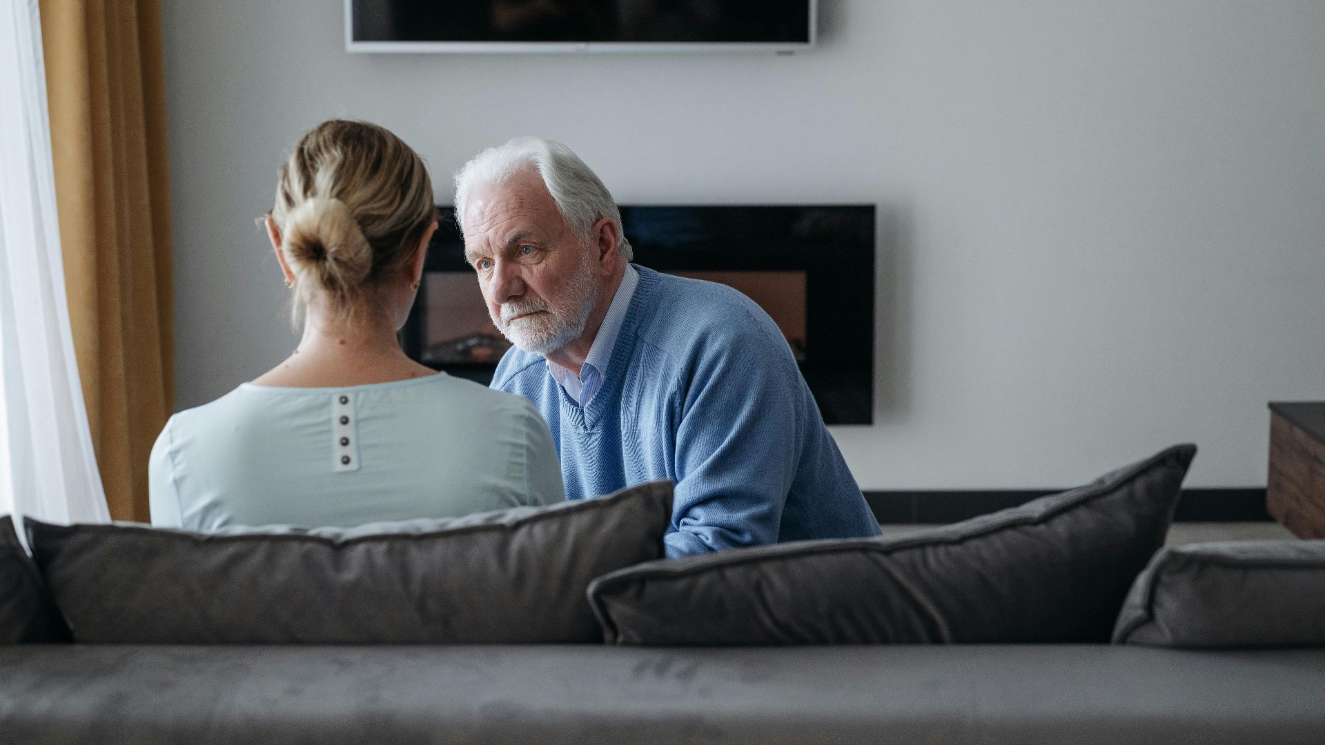 Senior couple in a warm, emotional moment in their modern living room.