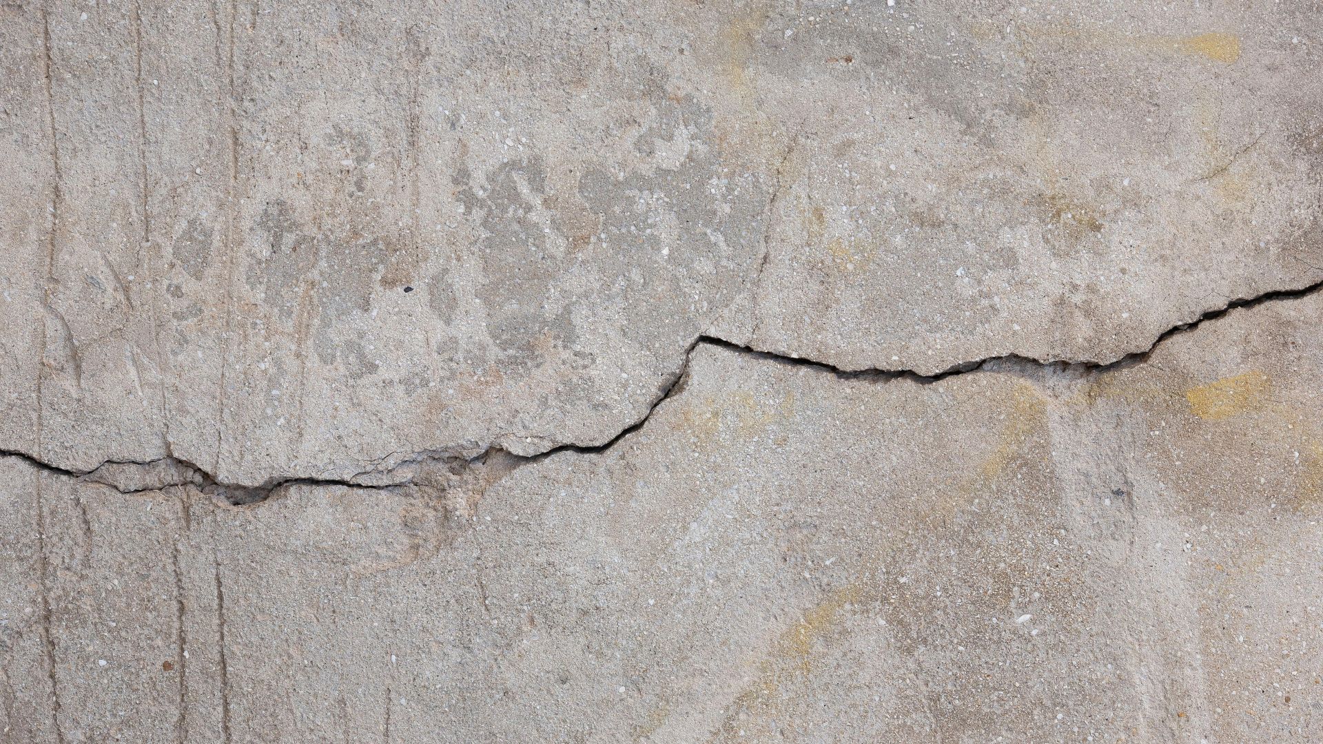 Detailed texture of a weathered concrete wall showing crack patterns.