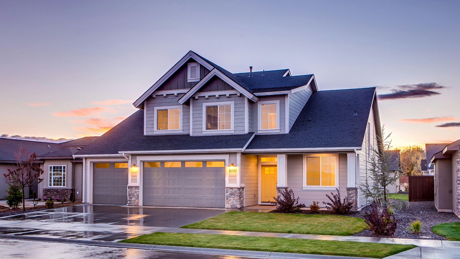 Elegant suburban home with driveway at sunset showcasing modern architecture.