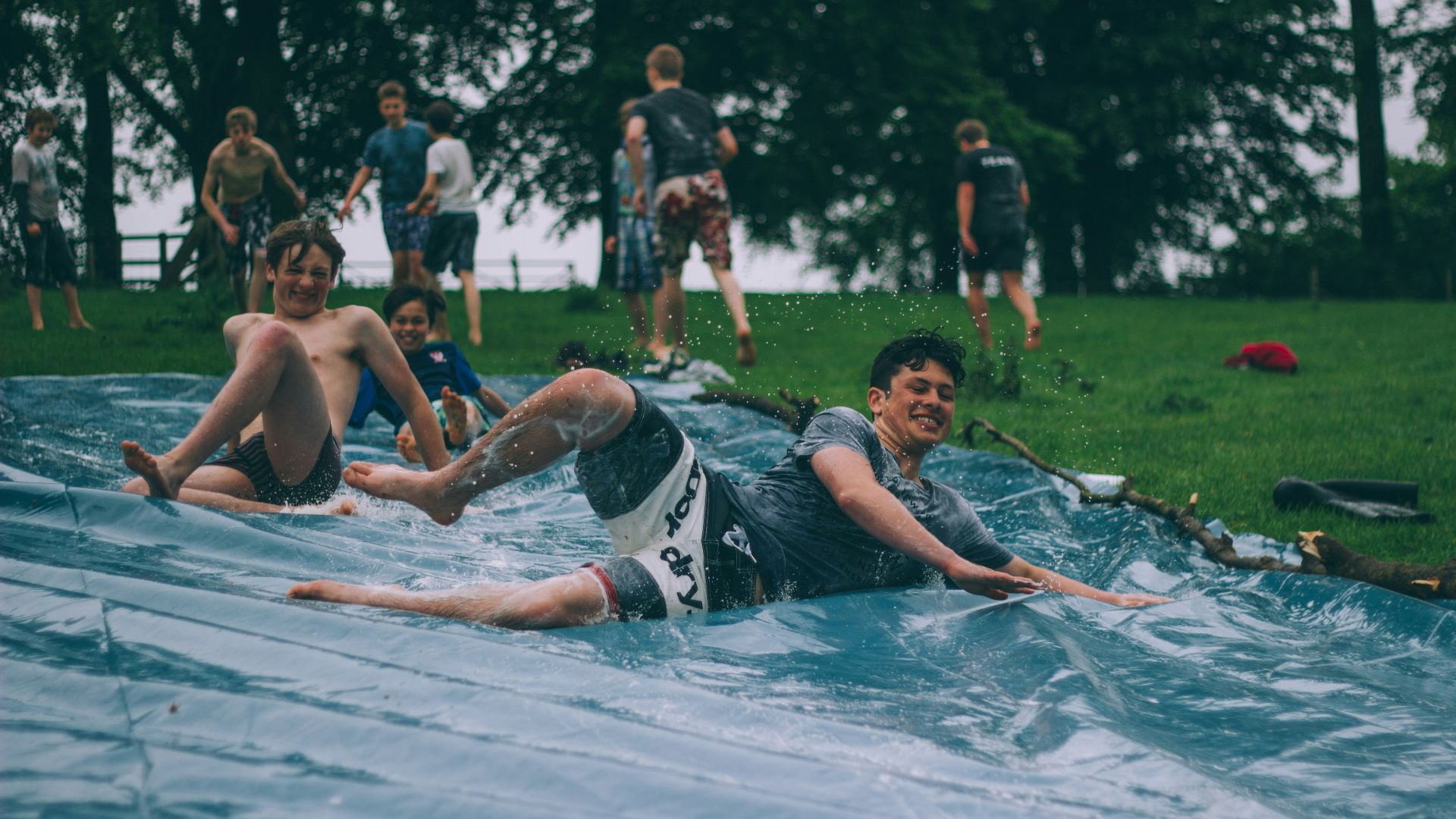 group of men sliding on blue canopy