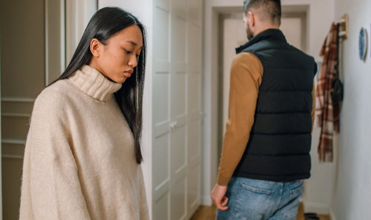 A couple experiencing relationship issues in a hallway, conveying emotional tension