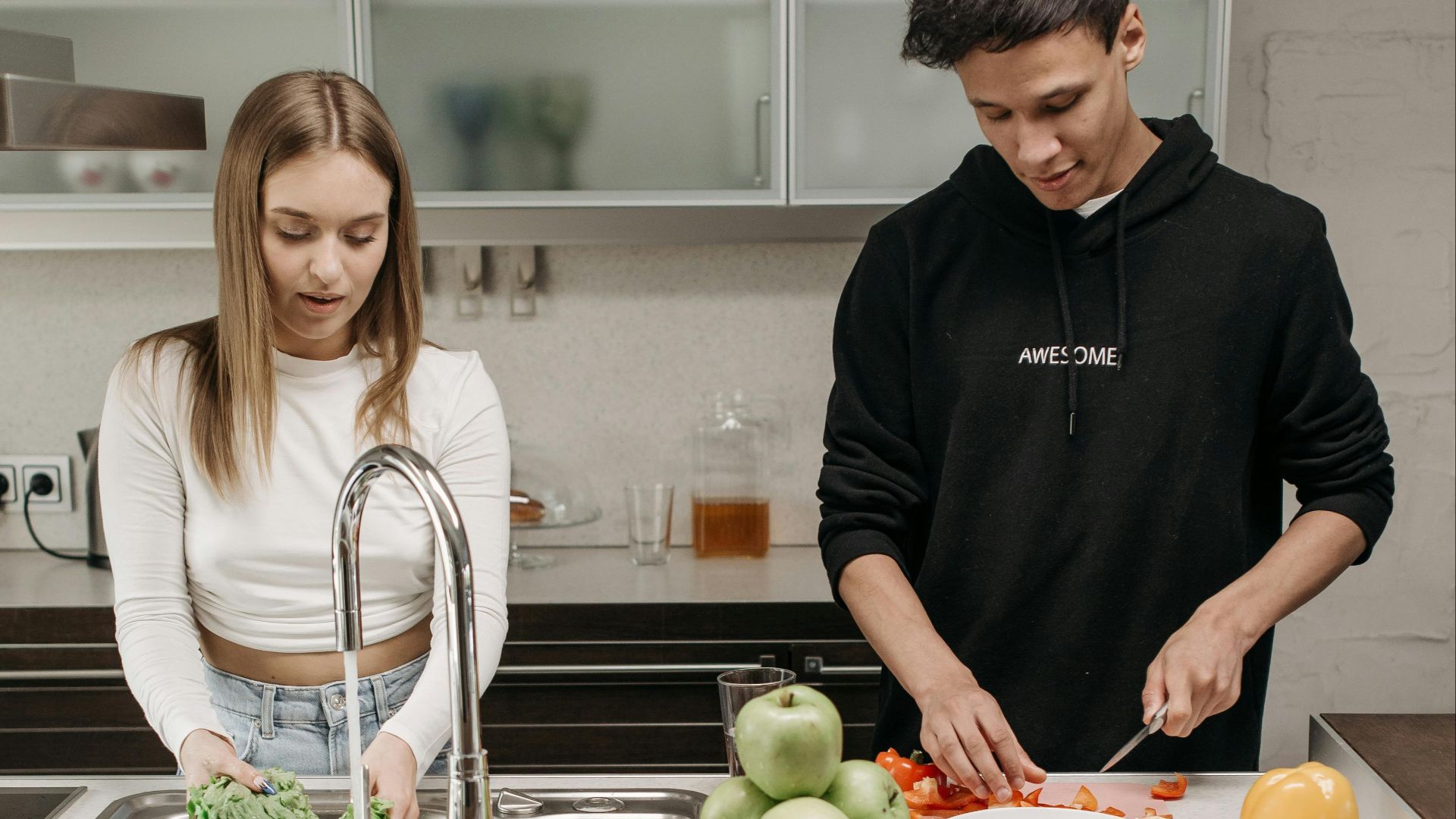 A couple preparing food together in their kitchen, highlighting teamwork and daily life.