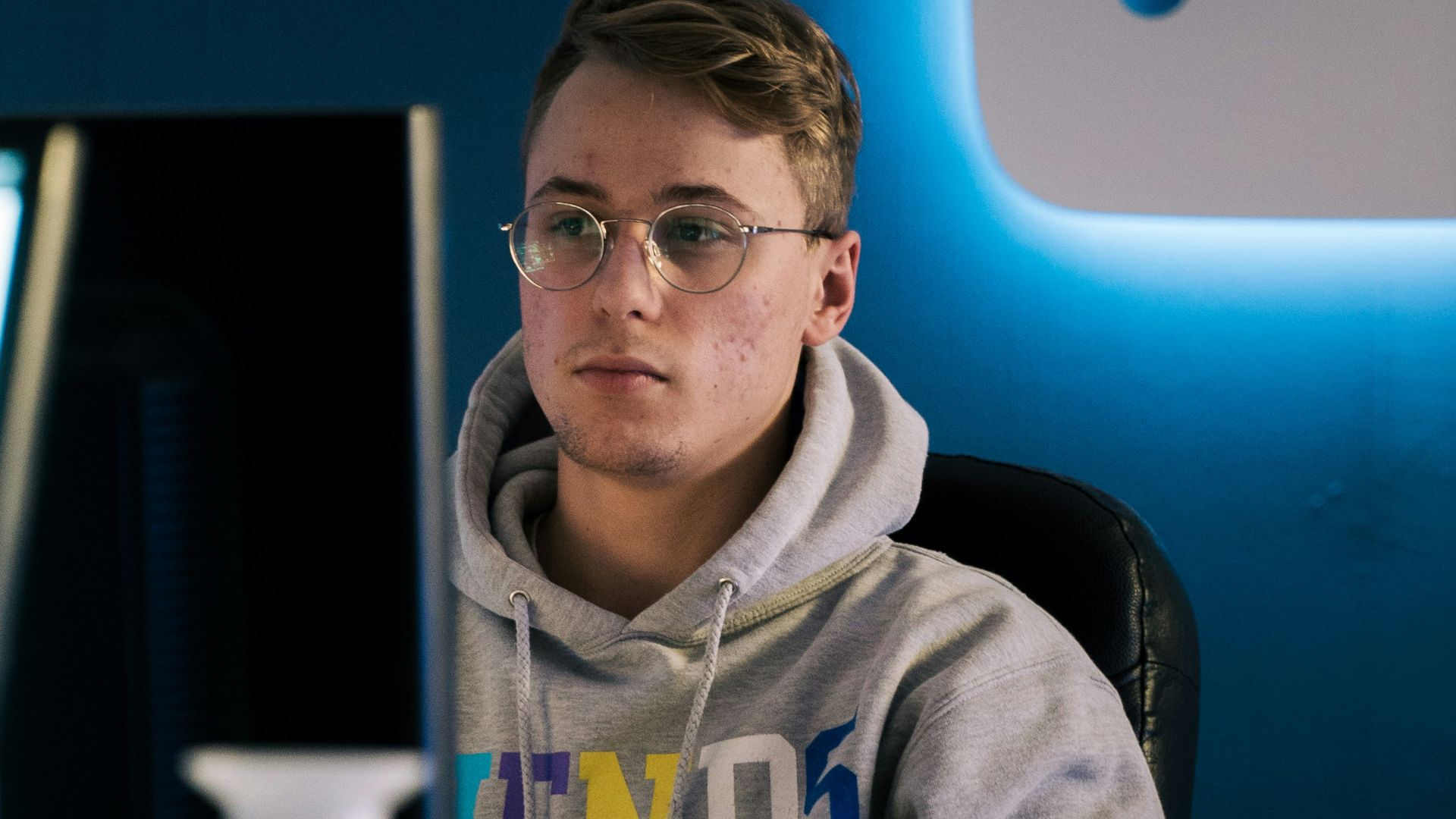 selective focus photography of man sitting on chair facing monitor