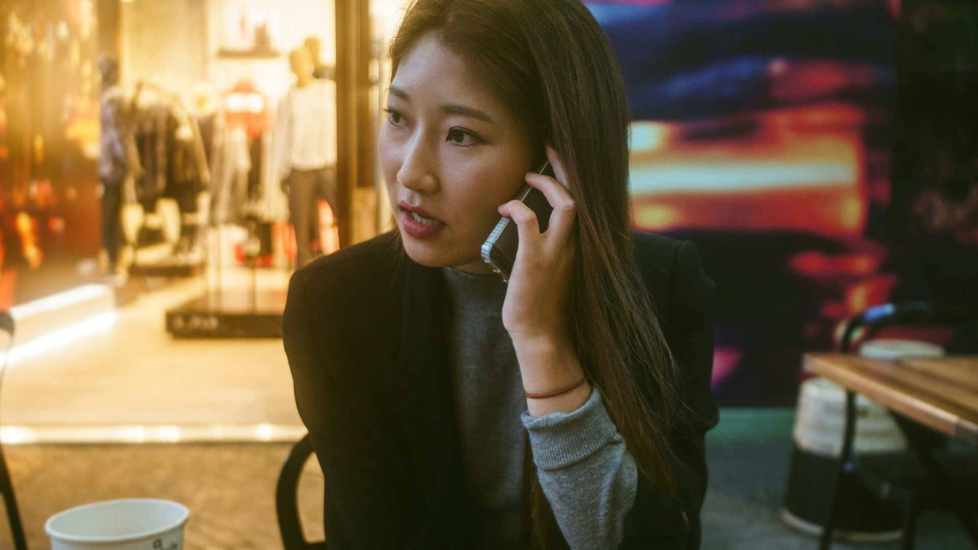 woman talking on phone outdoor in front of store