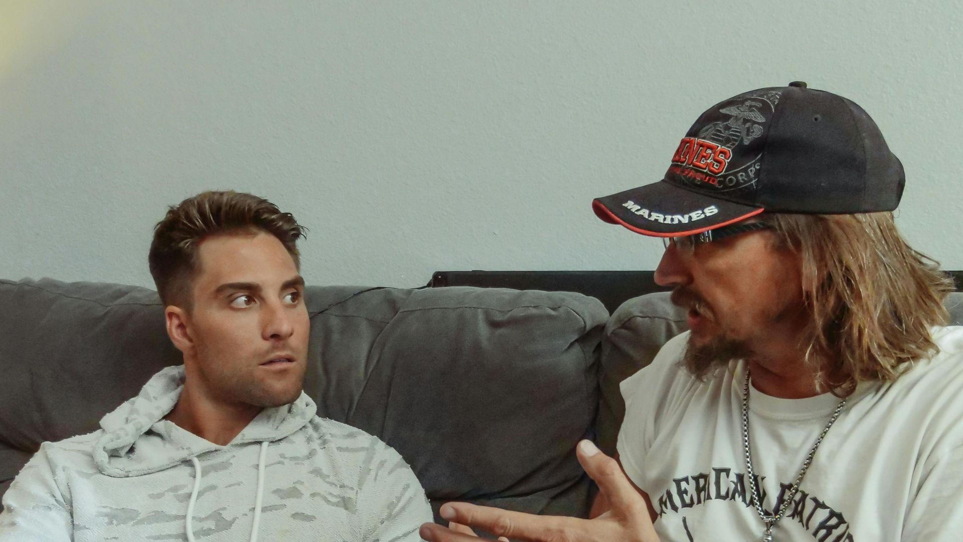 Father and son engaging in a deep conversation while sitting on a cozy sofa indoors.