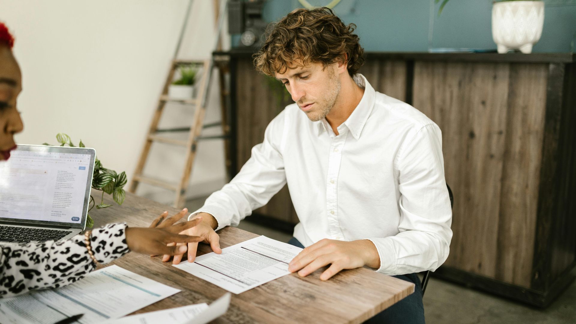 Two professionals discussing financial documents in an office setting.