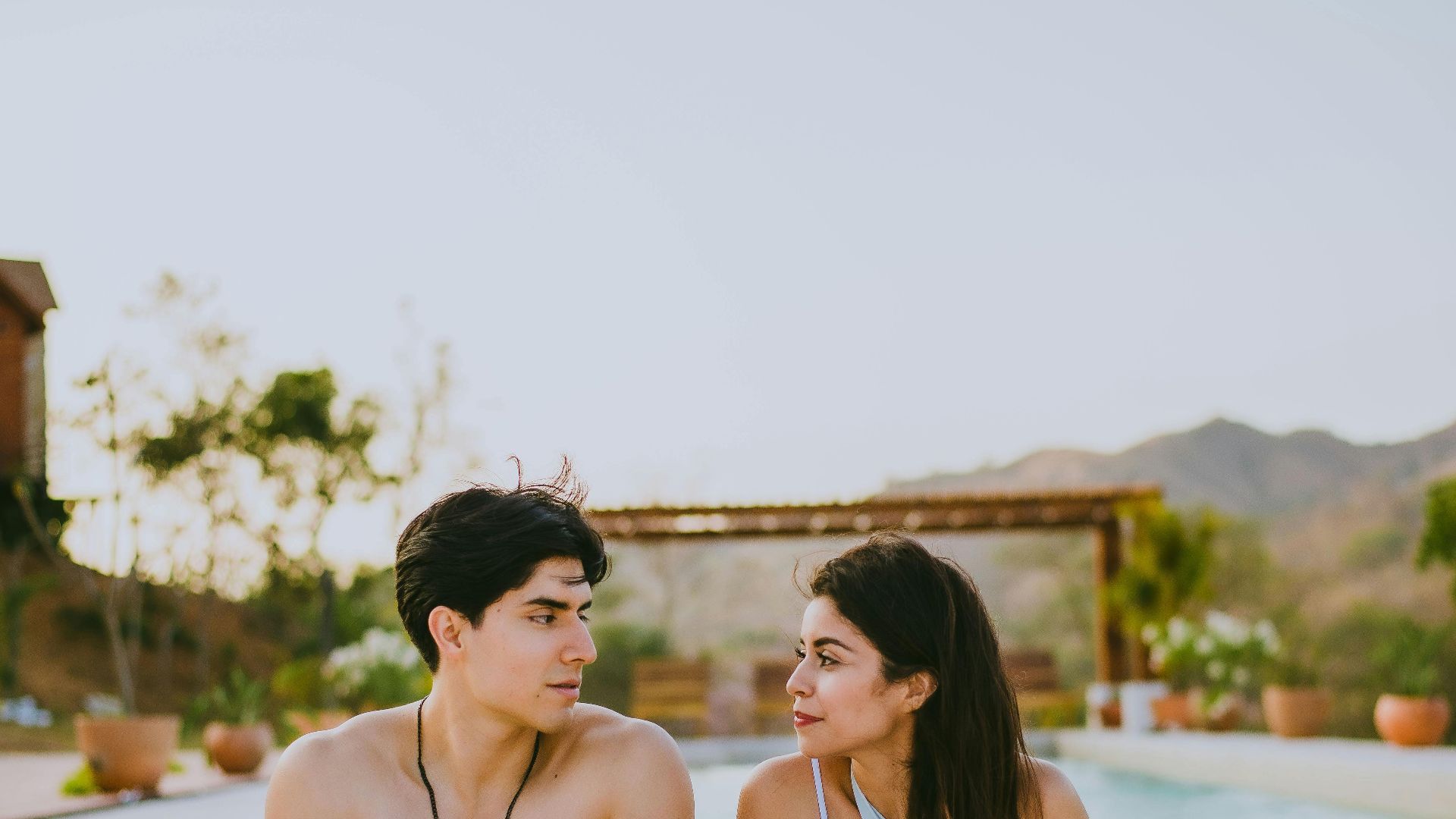 A couple enjoys a relaxing day at a resort pool, capturing summer vibes and tranquility.