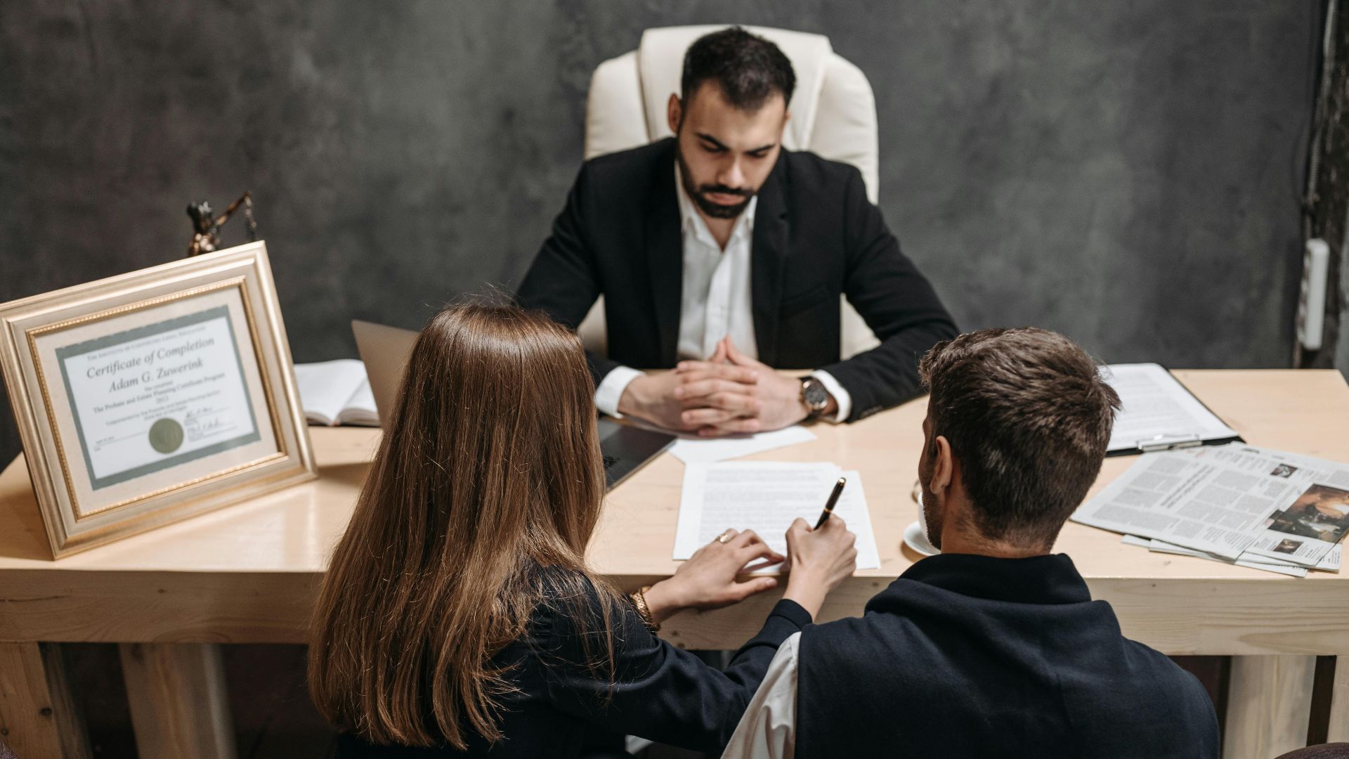 A lawyer discusses legal documents with clients in an office setting.
