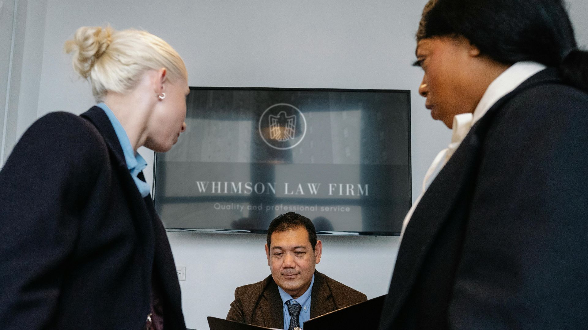 Diverse colleagues gathering in conference hall of law firm and discussing details of contract while working together