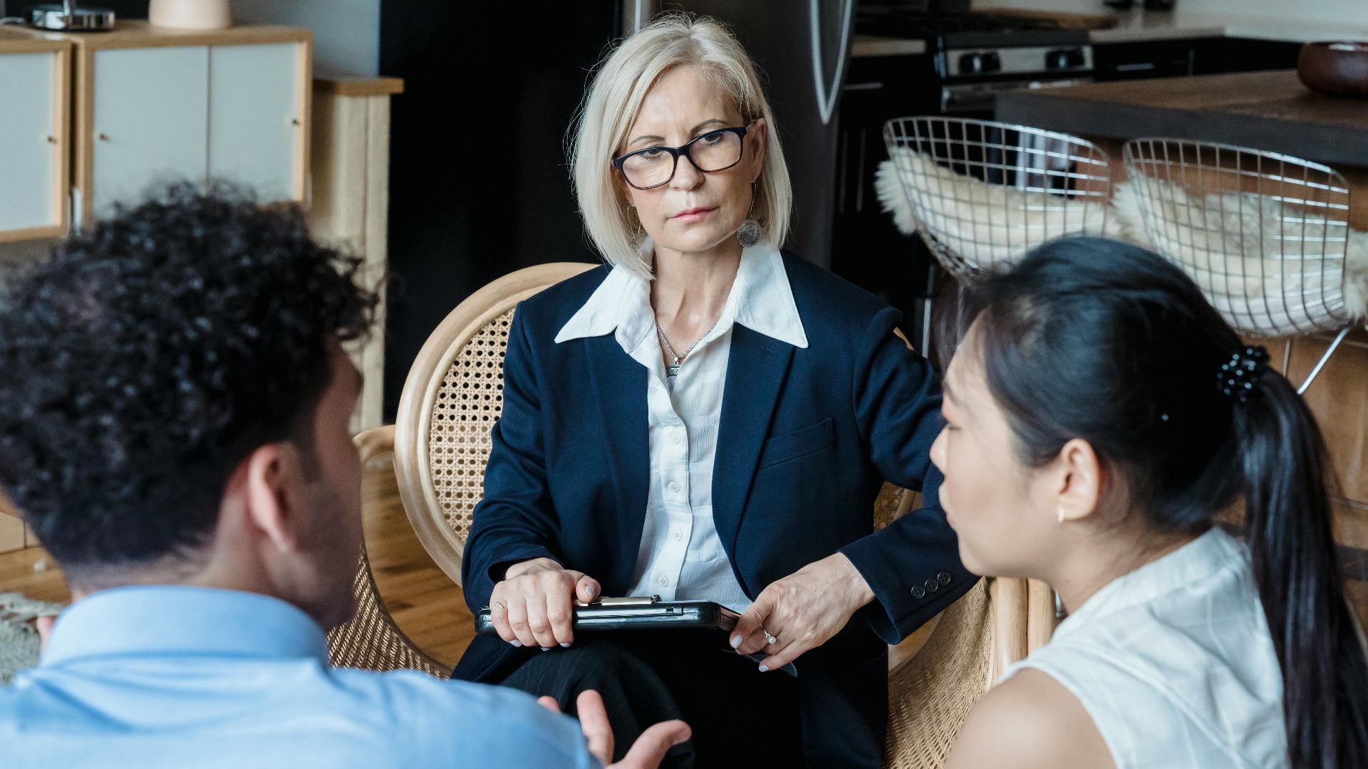 A professional therapist engages with a couple during a counseling session indoors.