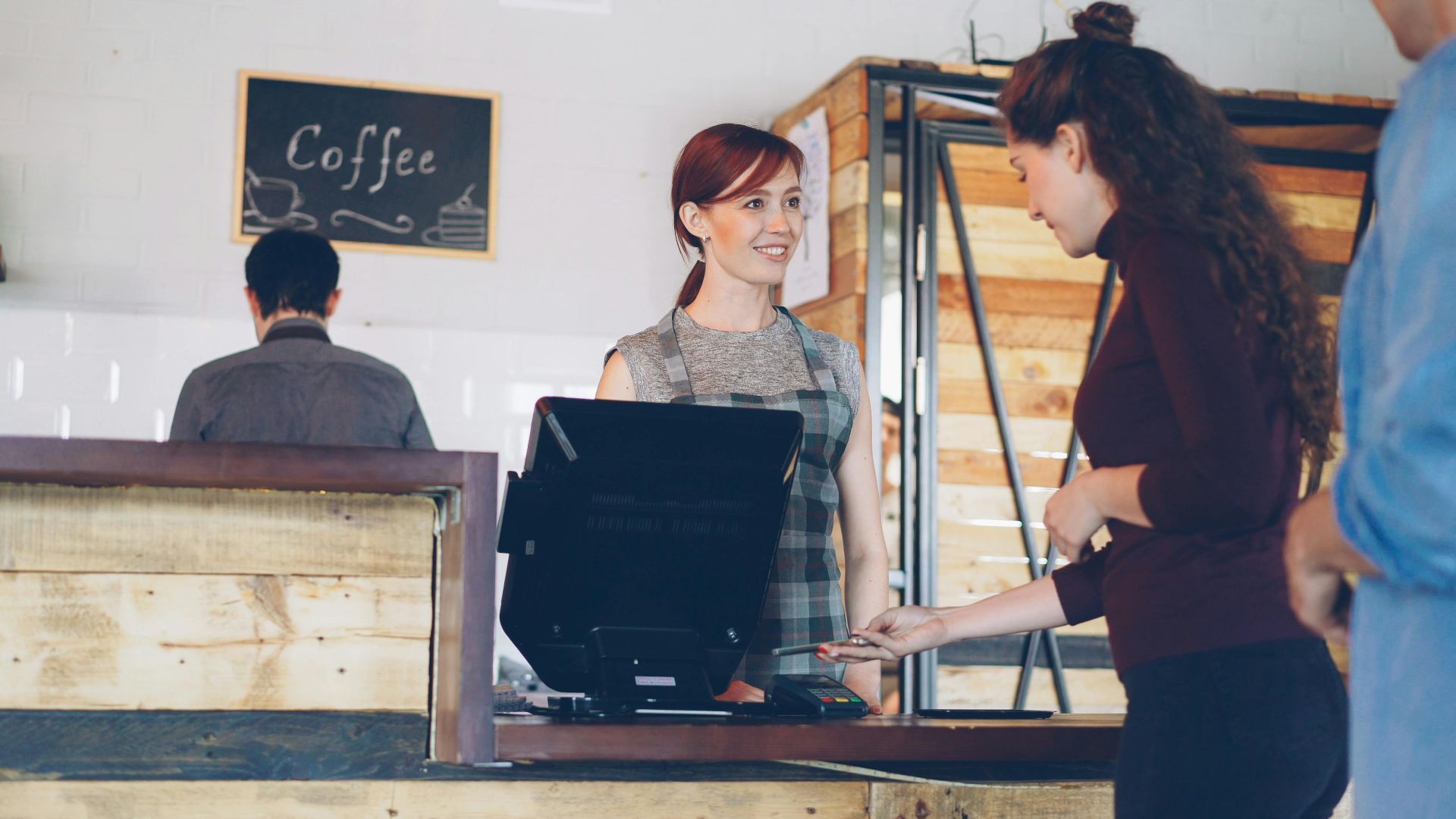 Barista serving customer in a charming coffee shop setting.