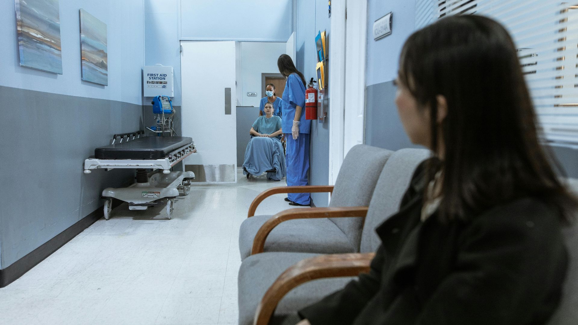 A hospital scene showing patients and medical staff in a corridor, illustrating healthcare environments.